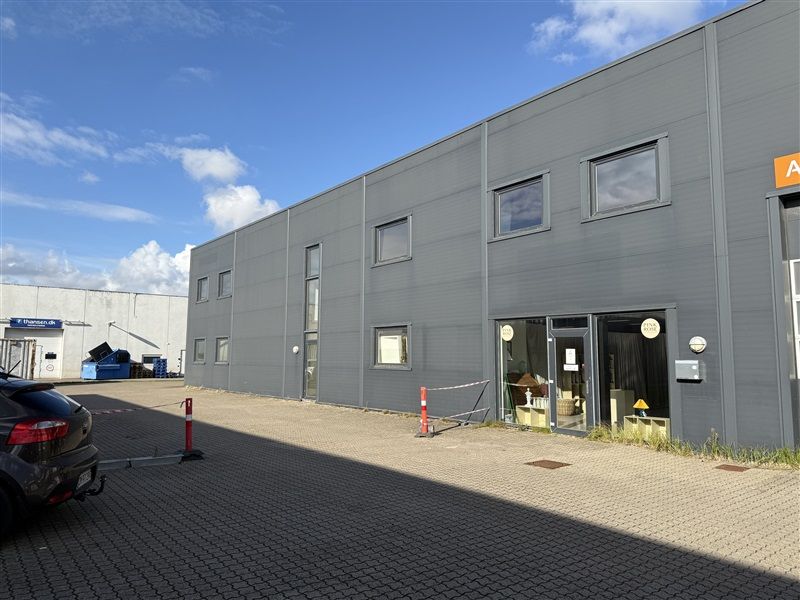 Et moderne erhvervslejemål med flere vinduer og hovedindgang placeret i Kirstinehøj-området med snedækket foran