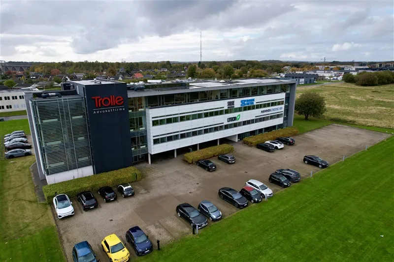En stor bygning med Trolle Advokatfirma tekst og logo, der ligger på Vesterballevej 25, lokale 6, 7000 Fredericia