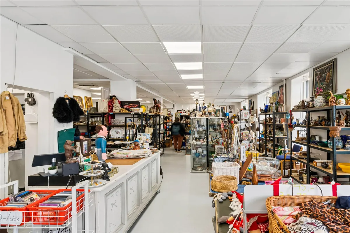 En hjørnebutik med håndværk og antikviteter og flere hylder med ting i glas og keramik