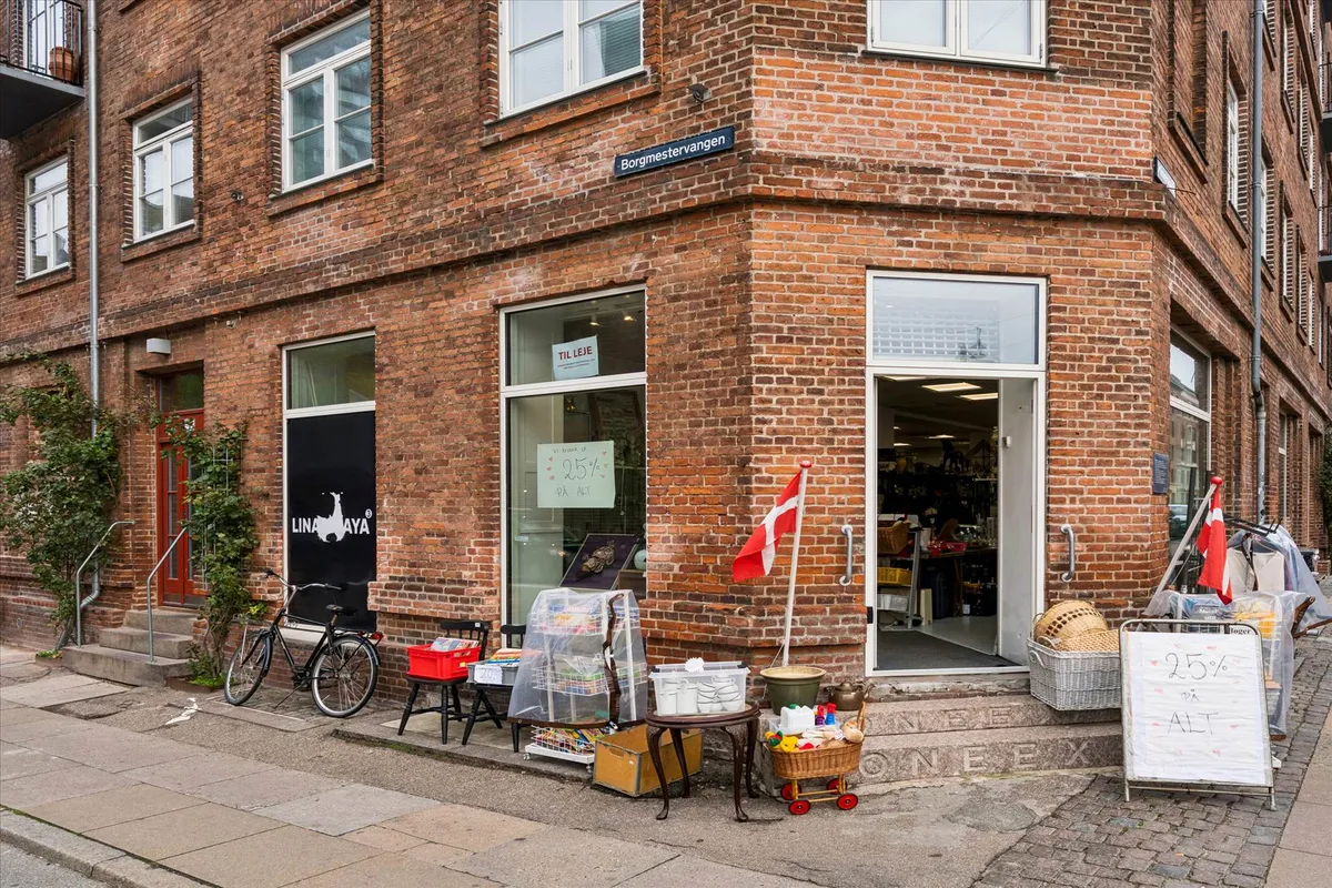 En hjørnebutik med navnet Lina YAYA, hvor der er en cykel og en rabatskilt med teksten 25% på alt.