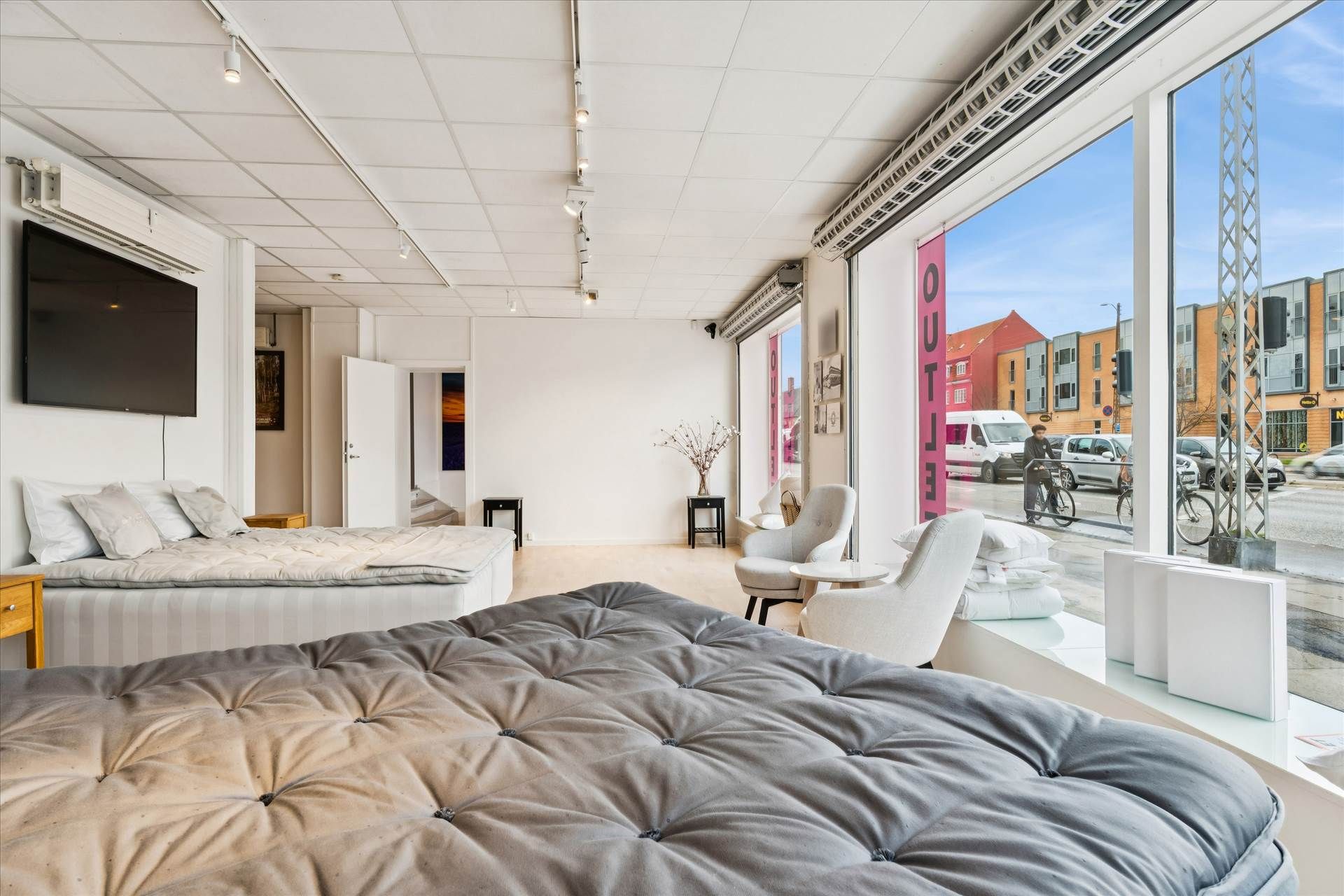 Erhvervslejemål med to soveværelser og udsigt mod Roskildevej. Store vinduer og højloftet med lysekroner og trægulve.