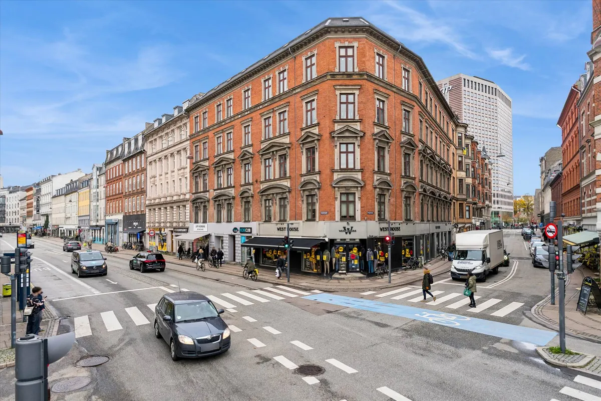 Vesterbros gadekorsning med biler og cyklister, mens en vogn med rødt lys venter på grønt