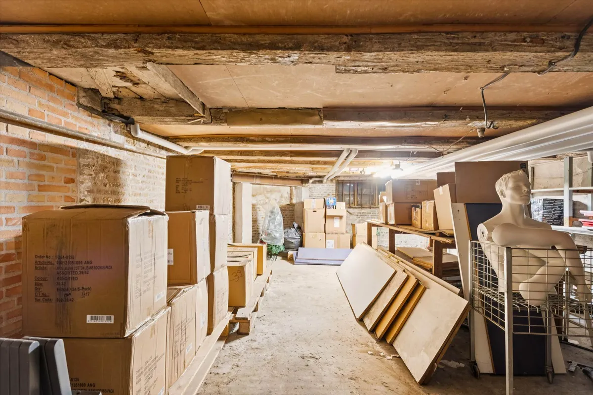 Lager med mange kasser og en mannekinstativ samt papkasser og træpæle