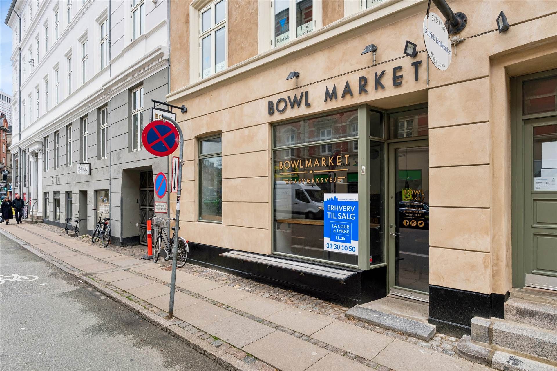 Lokale med Bowl Market-skilt og skilt med oplysninger om åbningstider og kontaktinformation.
