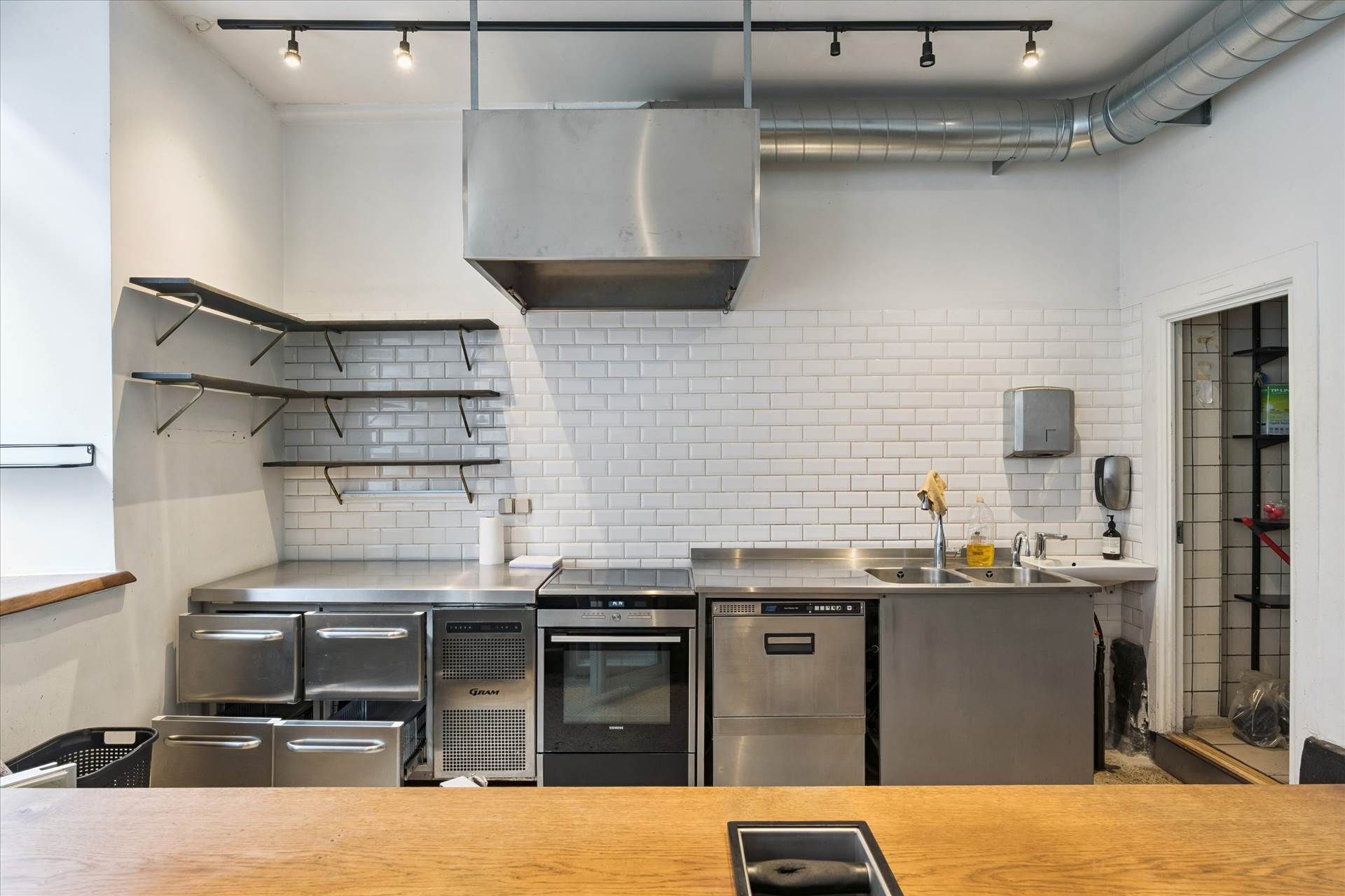 Moderne erhvervslokaler med kommercielle køkkener og store vinduer, lyse loftsrum og højt loft