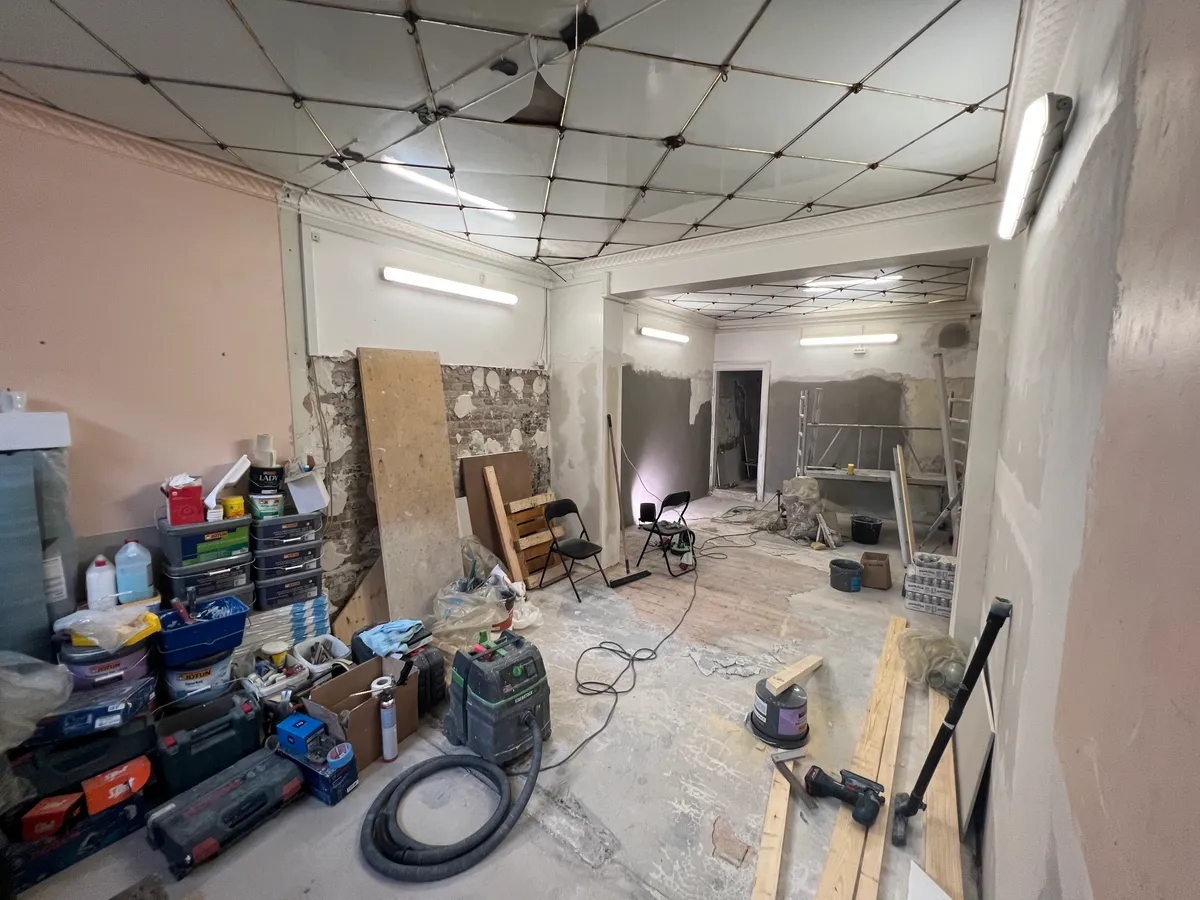 Under renovering af butikslokaler med støvsuger, værktøj og snedkerværk, samt opstillet møbler og lagermateriale