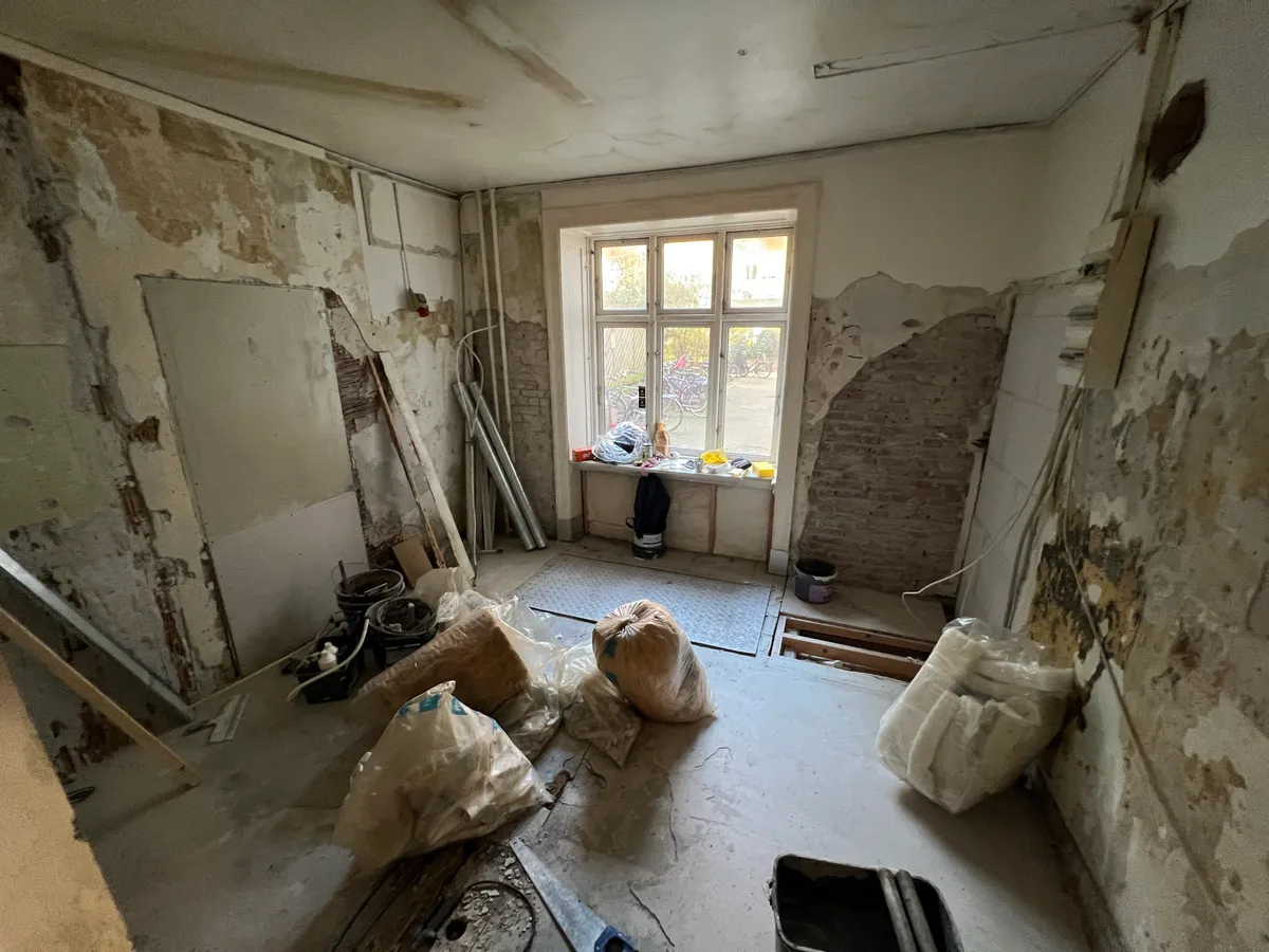 Nyrenoveret værksted med sammenlagt maling og byggeaffald, sammen med flere sække og en kasse for fællesbrug