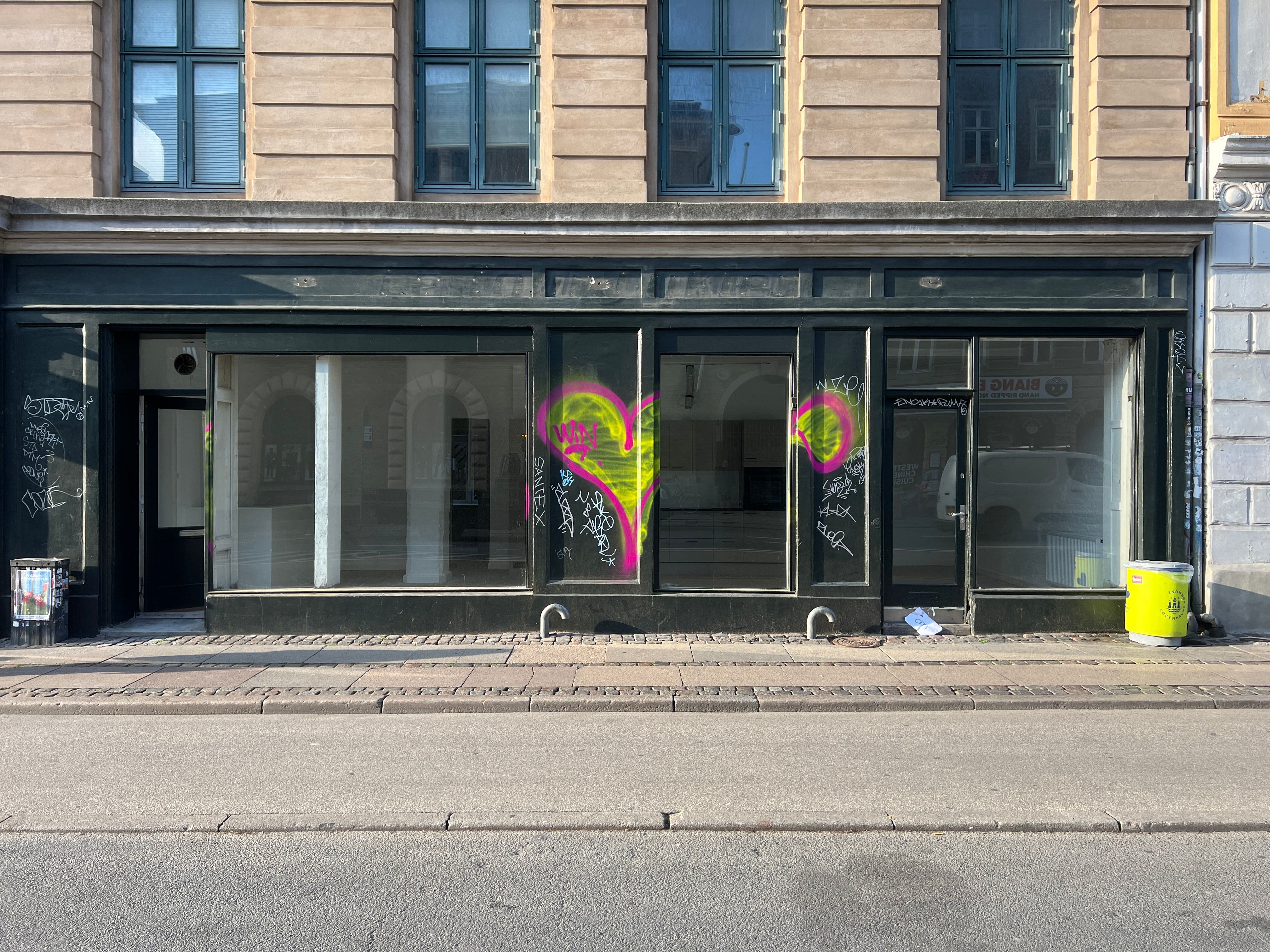 En butikslejemål på Fælledvej 21 med lyseglasvinduer og graffiti på ruder og væg