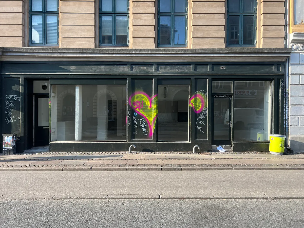 En butikslejemål på Fælledvej 21 med lyseglasvinduer og graffiti på ruder og væg