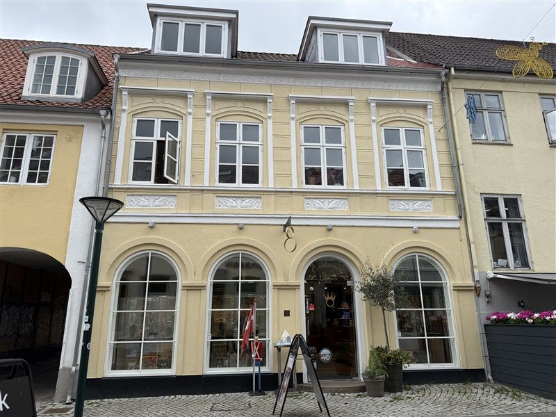 Guldsmeden på hovedgaden i Middelfart med en lille have og en røgflag foran døren