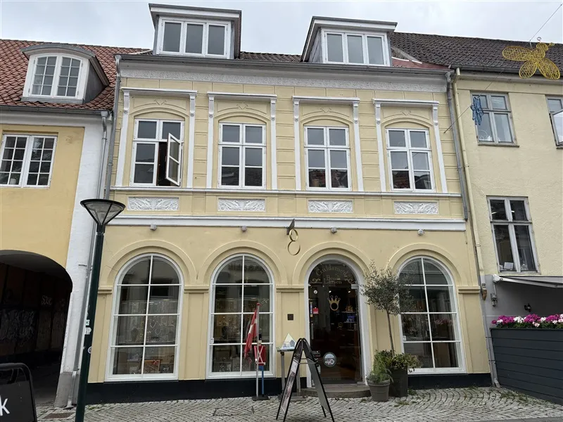 Guldsmeden på hovedgaden i Middelfart med en lille have og en røgflag foran døren