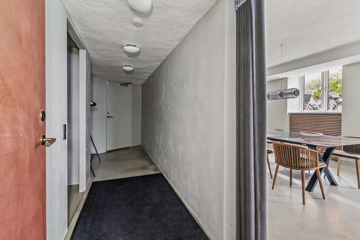 Moderne minimalistisk korridor med hvide vægge, trægulve og lysekroner samt møbler og vinduer