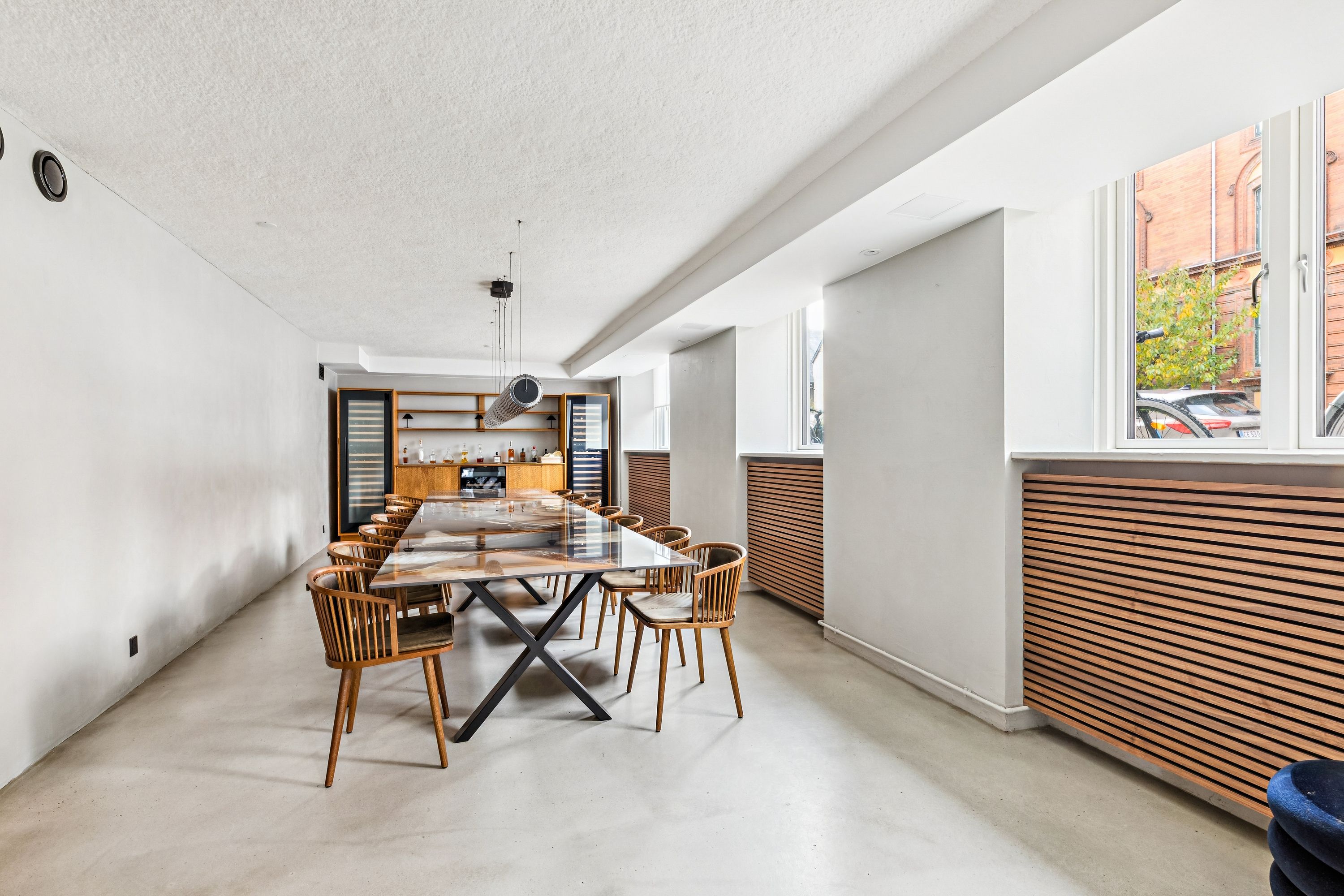 Lejlighed med elegant glasbord og stole i en moderne stue med hvide vægge og lyse gulv