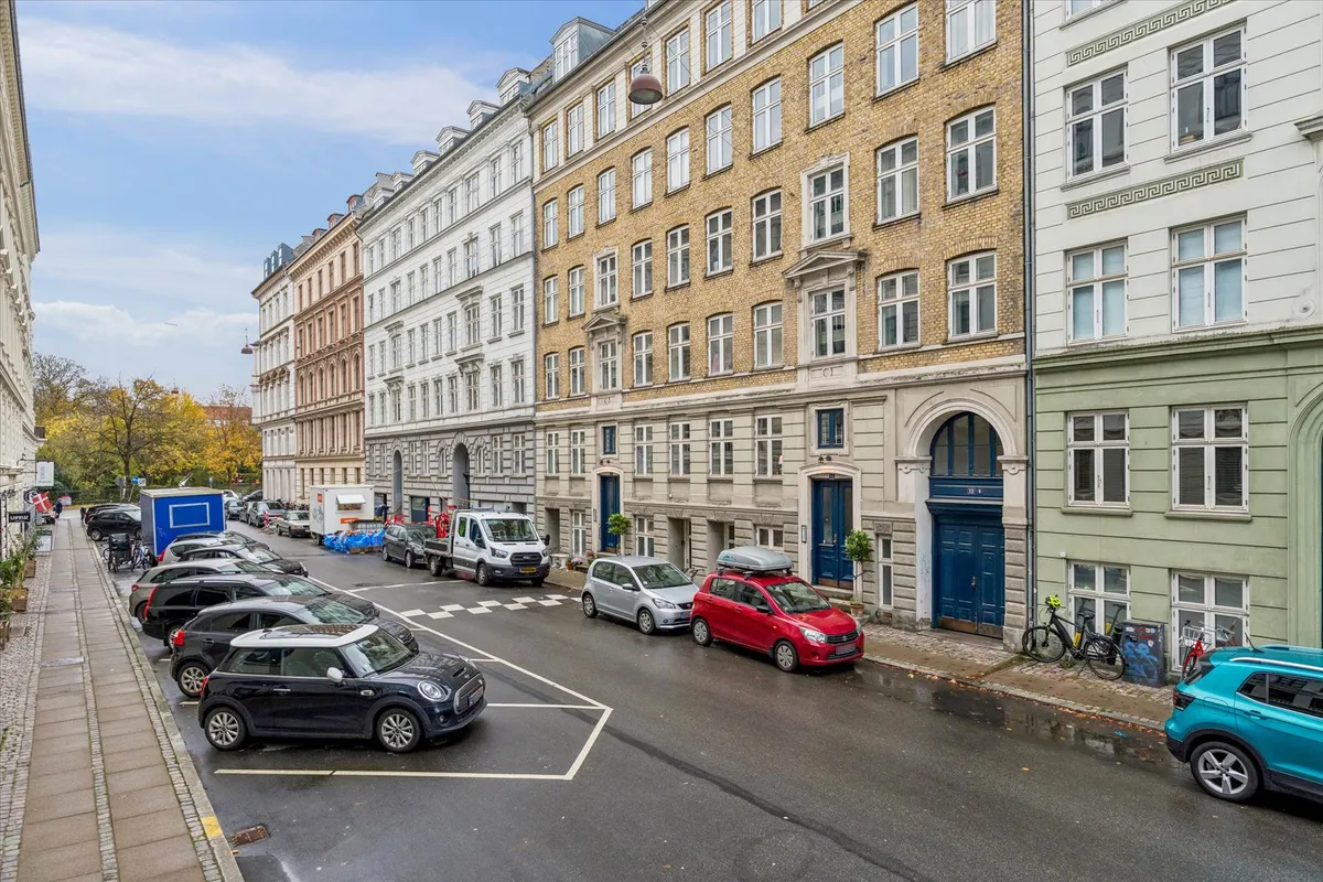 68 m² indbydende kontor/klinik på Turesensgade 11 i København K. Køretøjer parkeret langs siderne af gaden. To høje