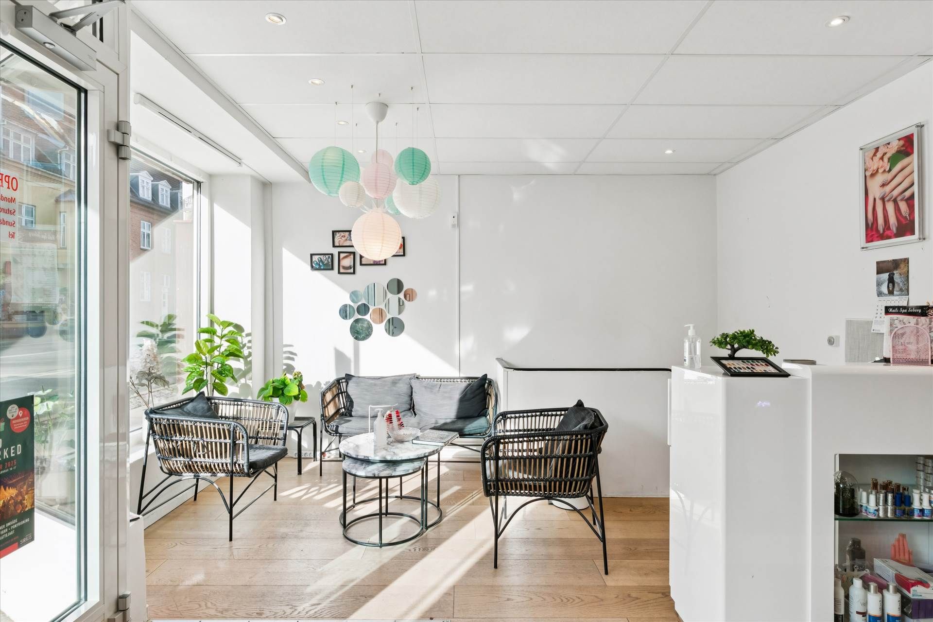 Inde i en indbydende butik med en hvid væg og loft samt et glasdør og et bord med en plade på.