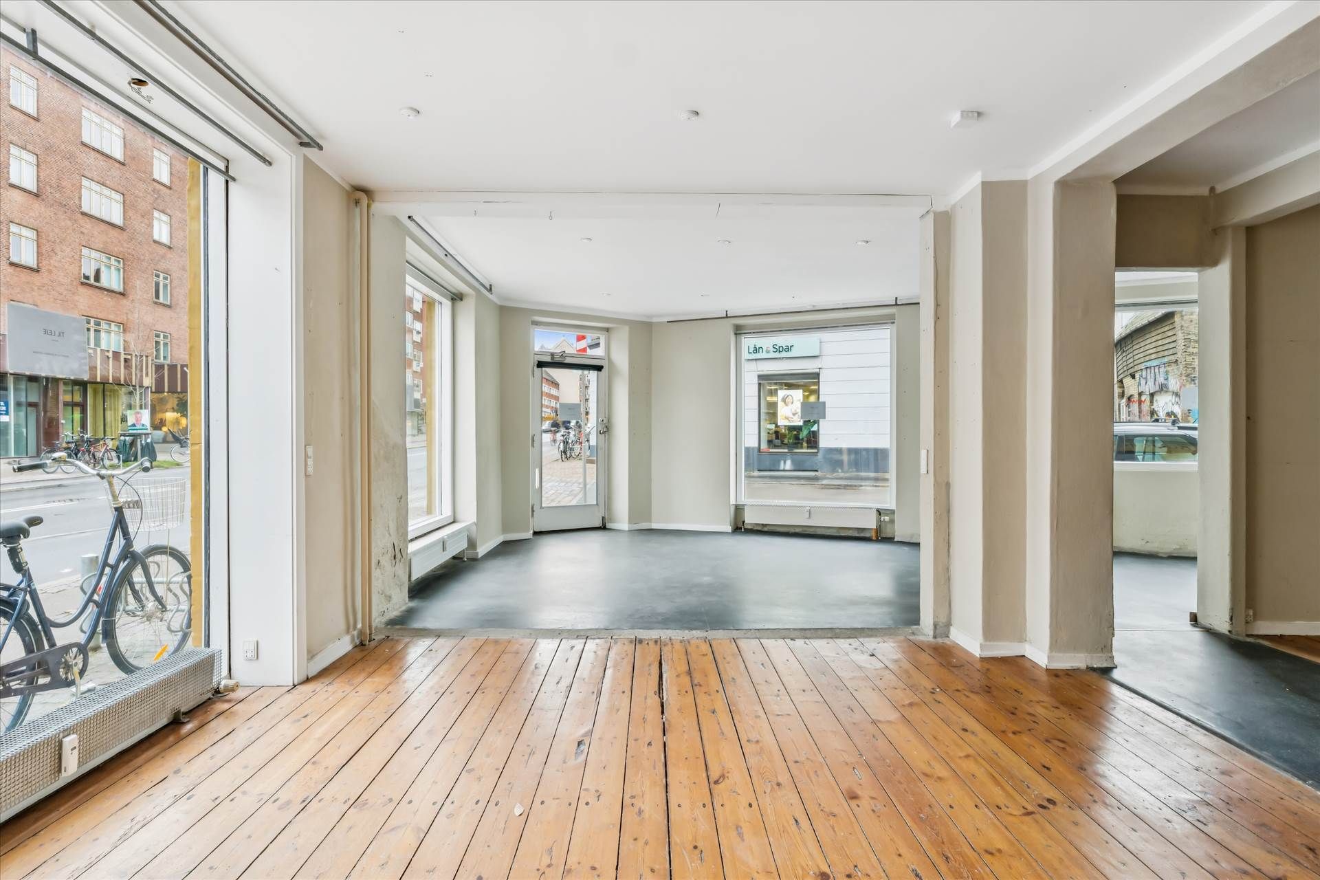 Store glasruder, højt loft, lys og rummelige lokaler med trægulv og flere indgange