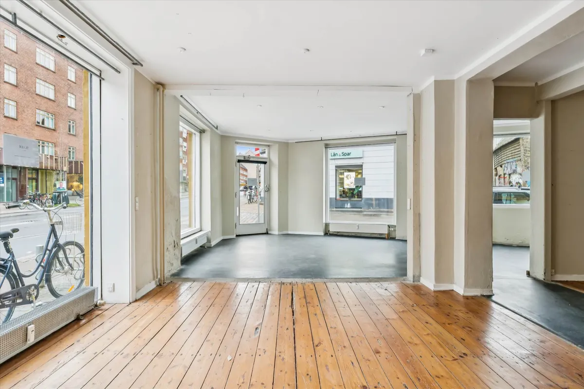Store glasruder, højt loft, lys og rummelige lokaler med trægulv og flere indgange