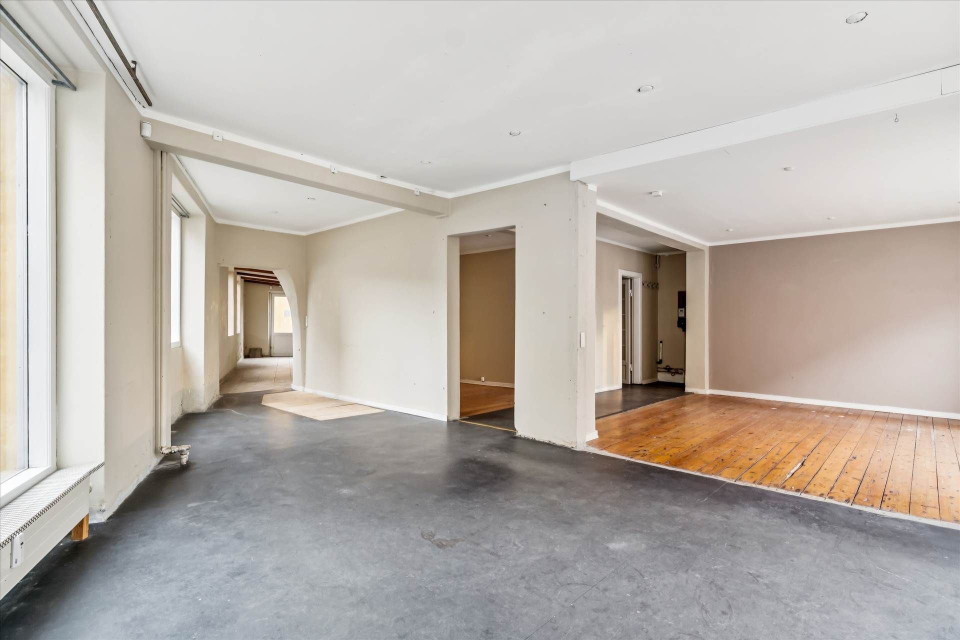 En stor hjørnebutik med moderne interiør og højt loft samt store vinduer med udsigt til gaden