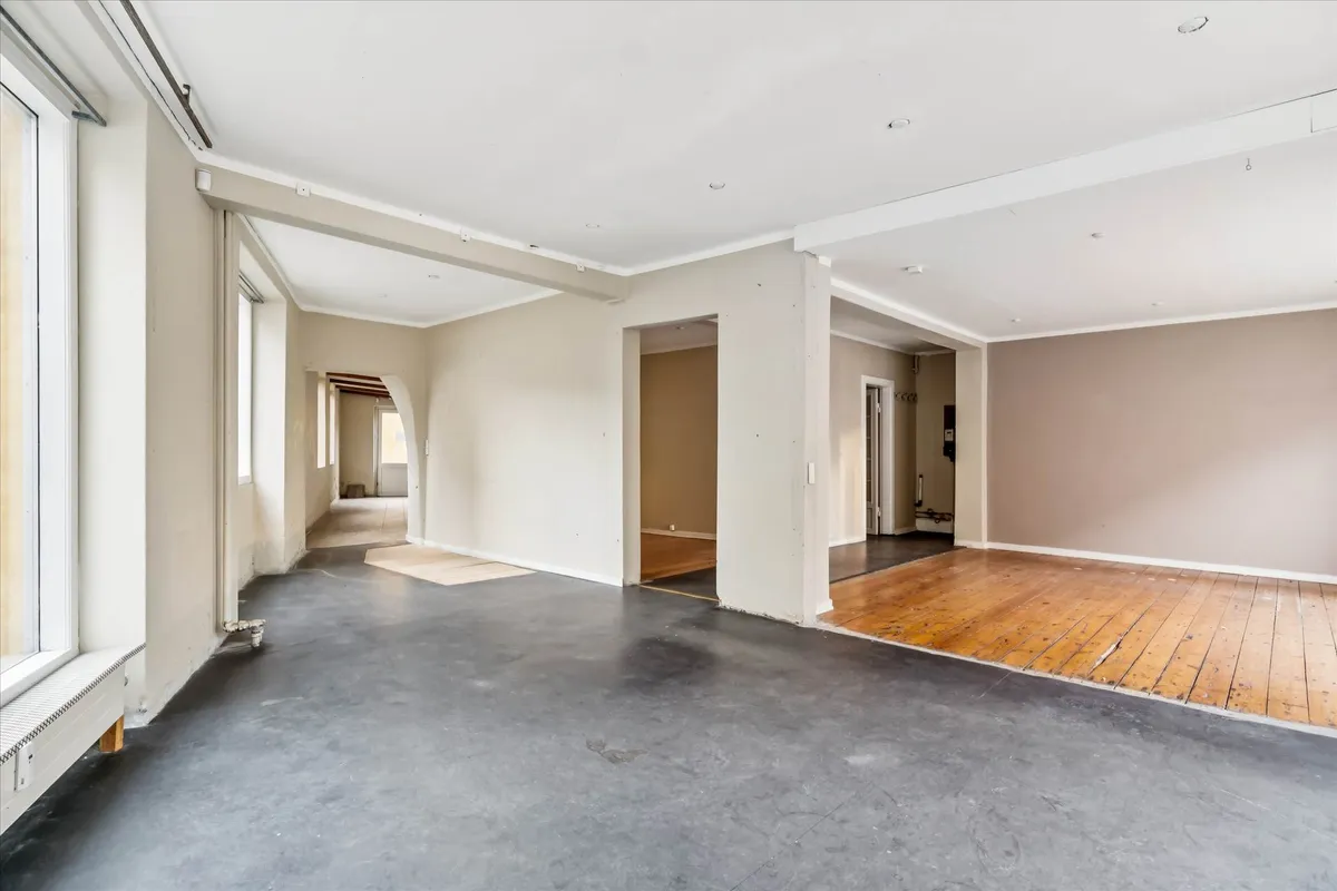 En stor hjørnebutik med moderne interiør og højt loft samt store vinduer med udsigt til gaden