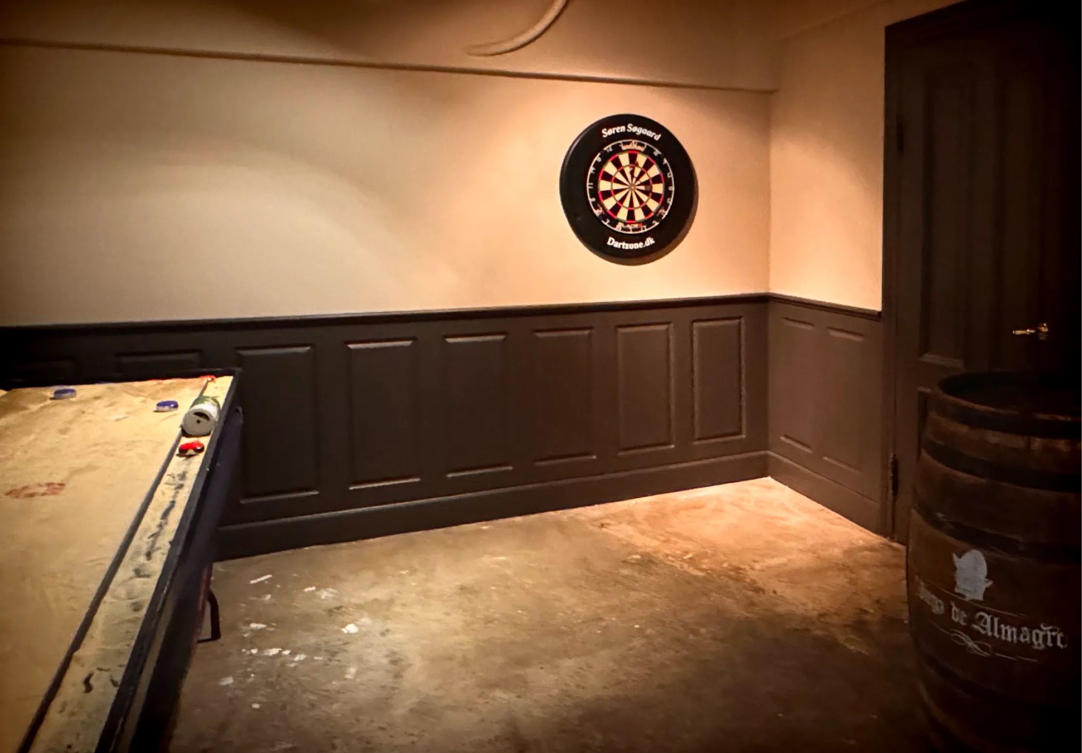 Selskabslokale og take-away på Østerbro med darte-væg, trækasse, træbord og gulv med pletter