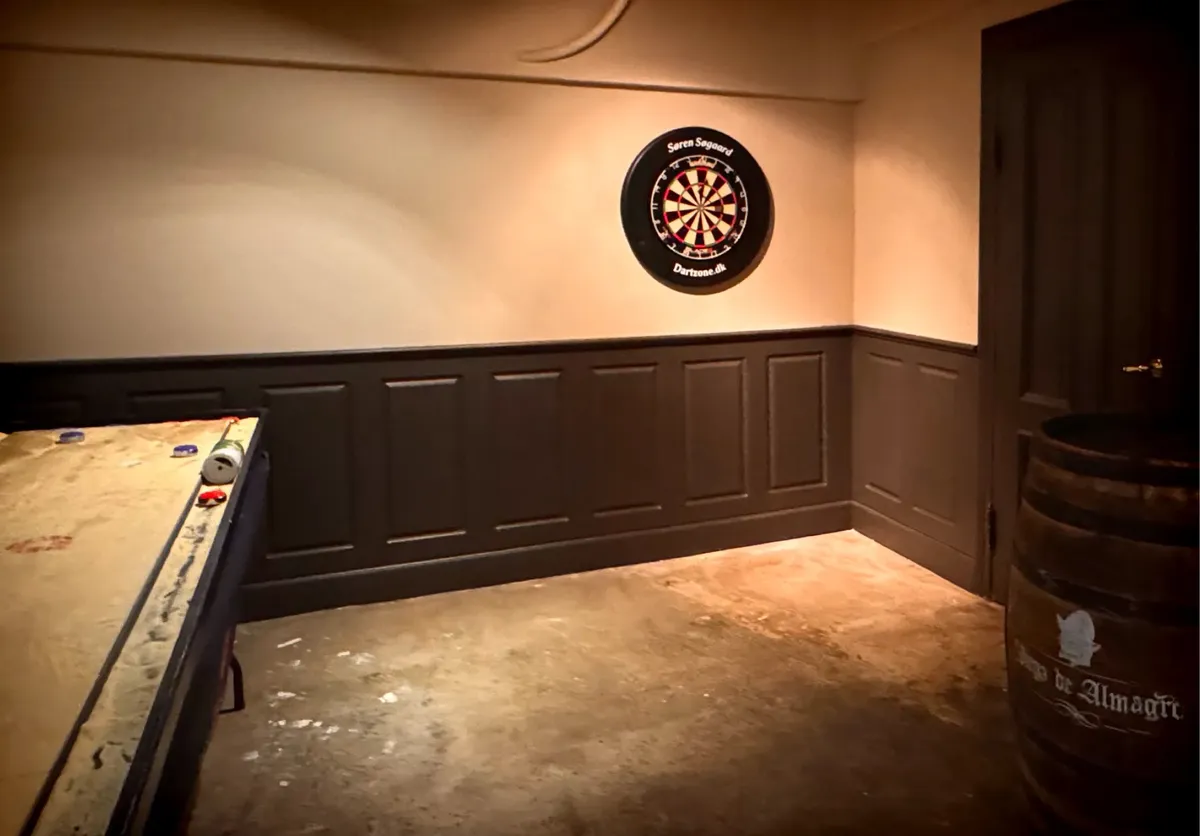 Selskabslokale og take-away på Østerbro med darte-væg, trækasse, træbord og gulv med pletter