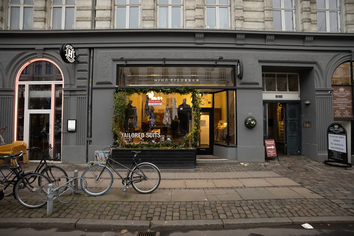 Frederiksborggade 37, 1360 København, med butikker og cykler foran, smykker i vinduet og skilte for gold and coin shop og Miko Firouzans butik