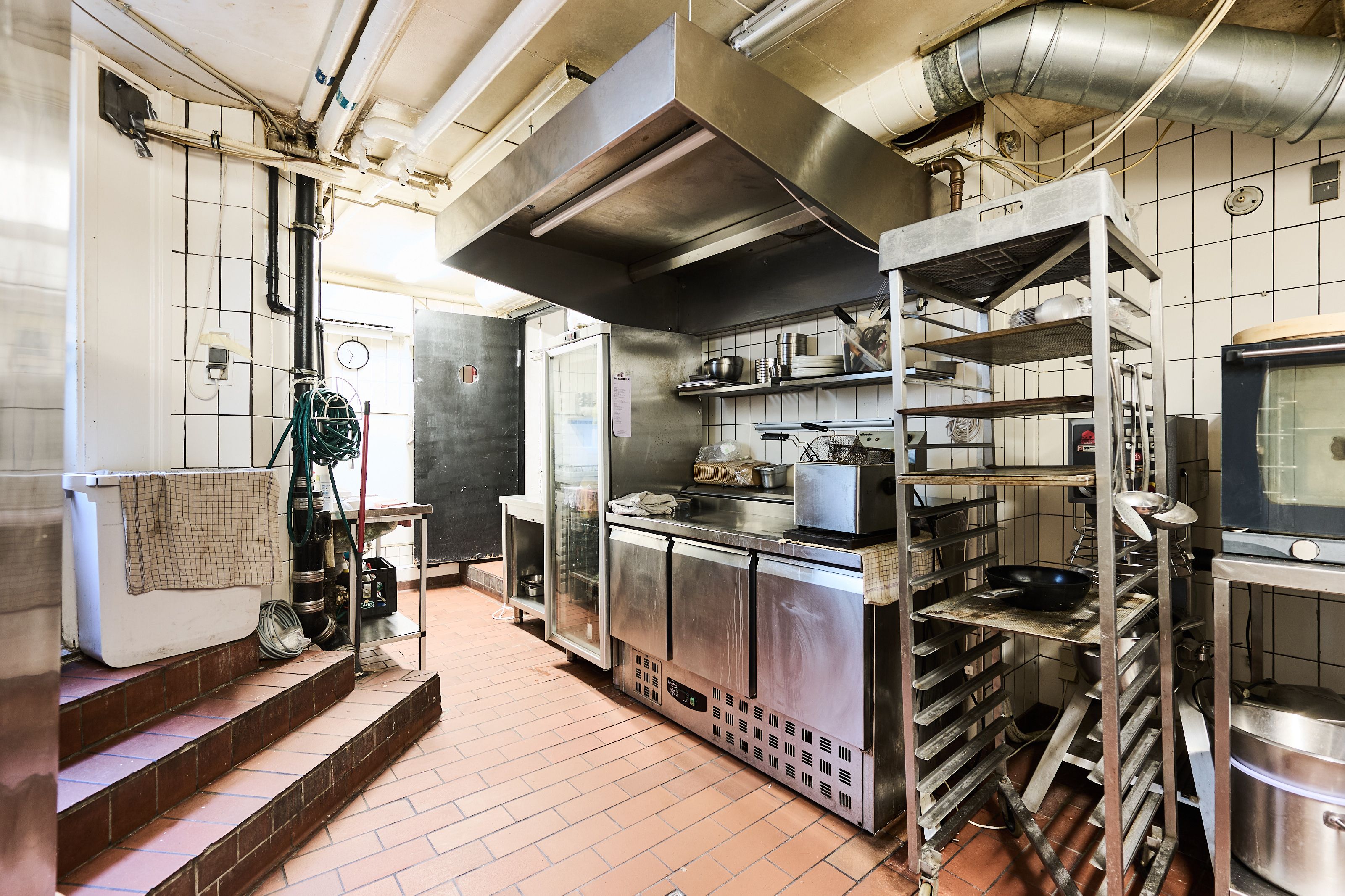 Investeringsejerlejlighed i Dronningens Tværgade, København K med moderne køkken med rustfri stålapparater, udendørs tøjvaskeri og lyse loftsrum til renovering