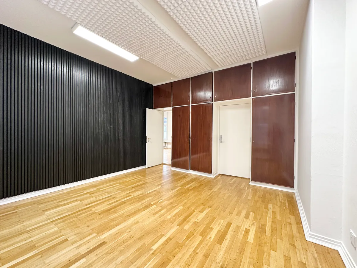 Ledig kontor til leje på Nedergade 33, 1. sal i Odense C. Rummet har massivt trægulv, højloft, og store vinduer. Ingen møbler.