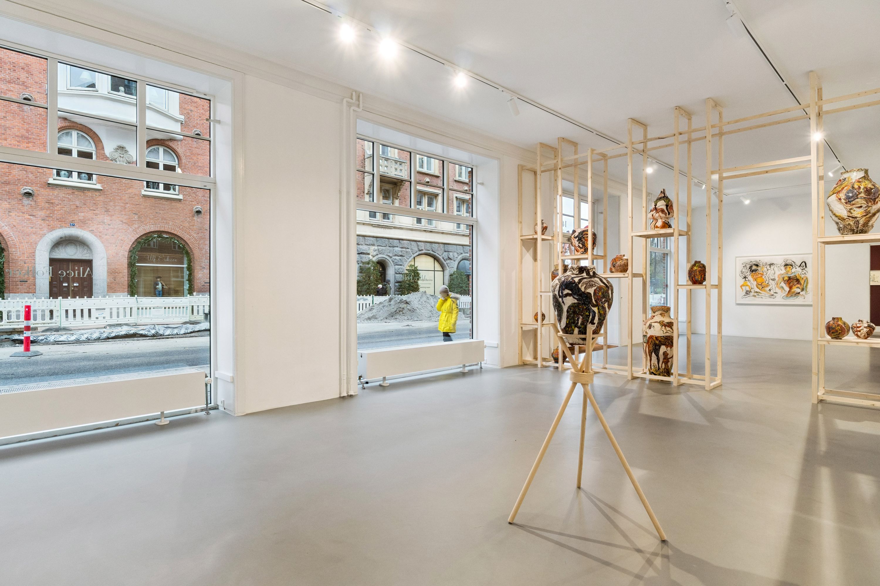 Kunstværk med ler og keramik i butiksvindue med stort lys og træhylder