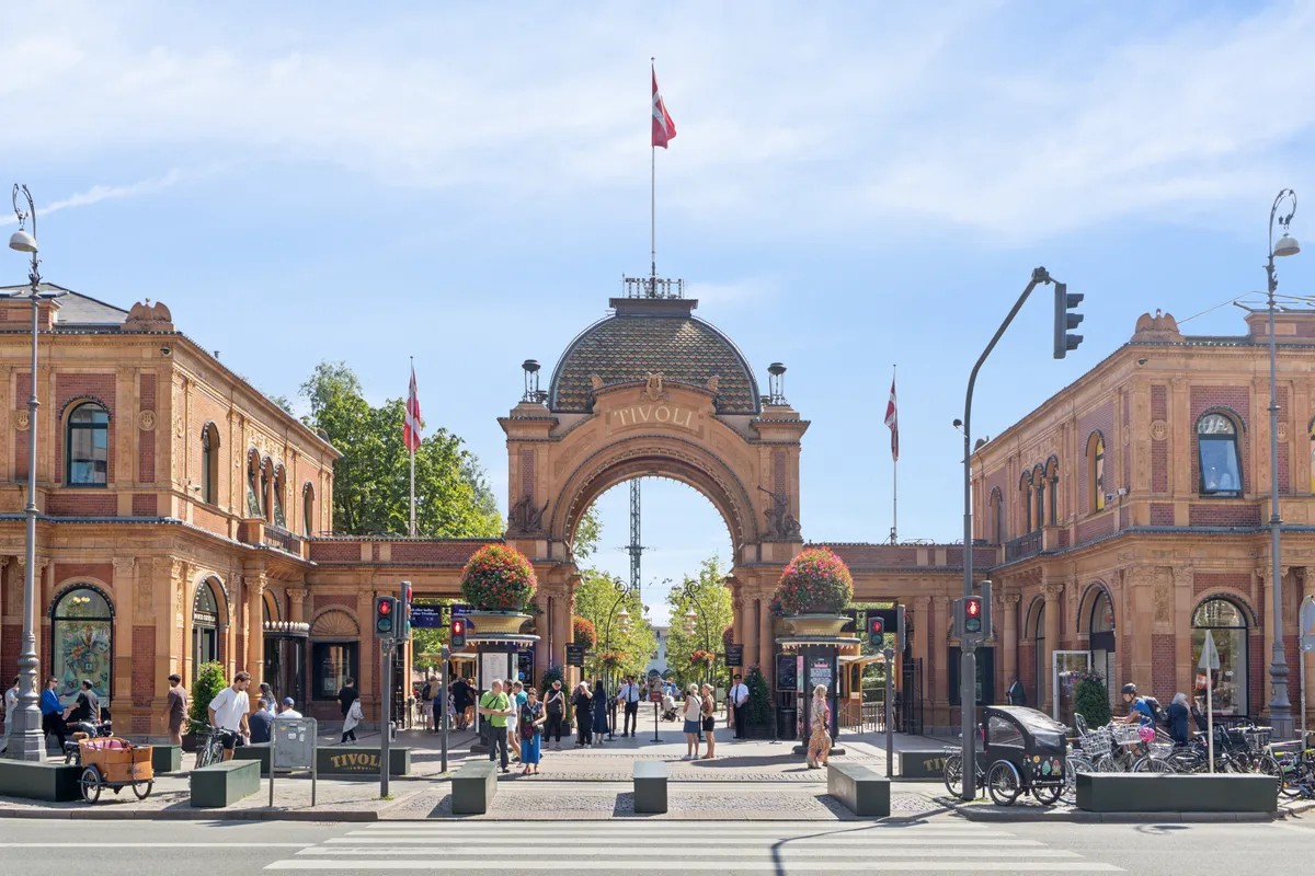 Idéel placering i Tivoli i København med højt til loftet og flot udsigt til byen og Tivoli. Mange mennesker og cykler samt arkitektoniske detaljer
