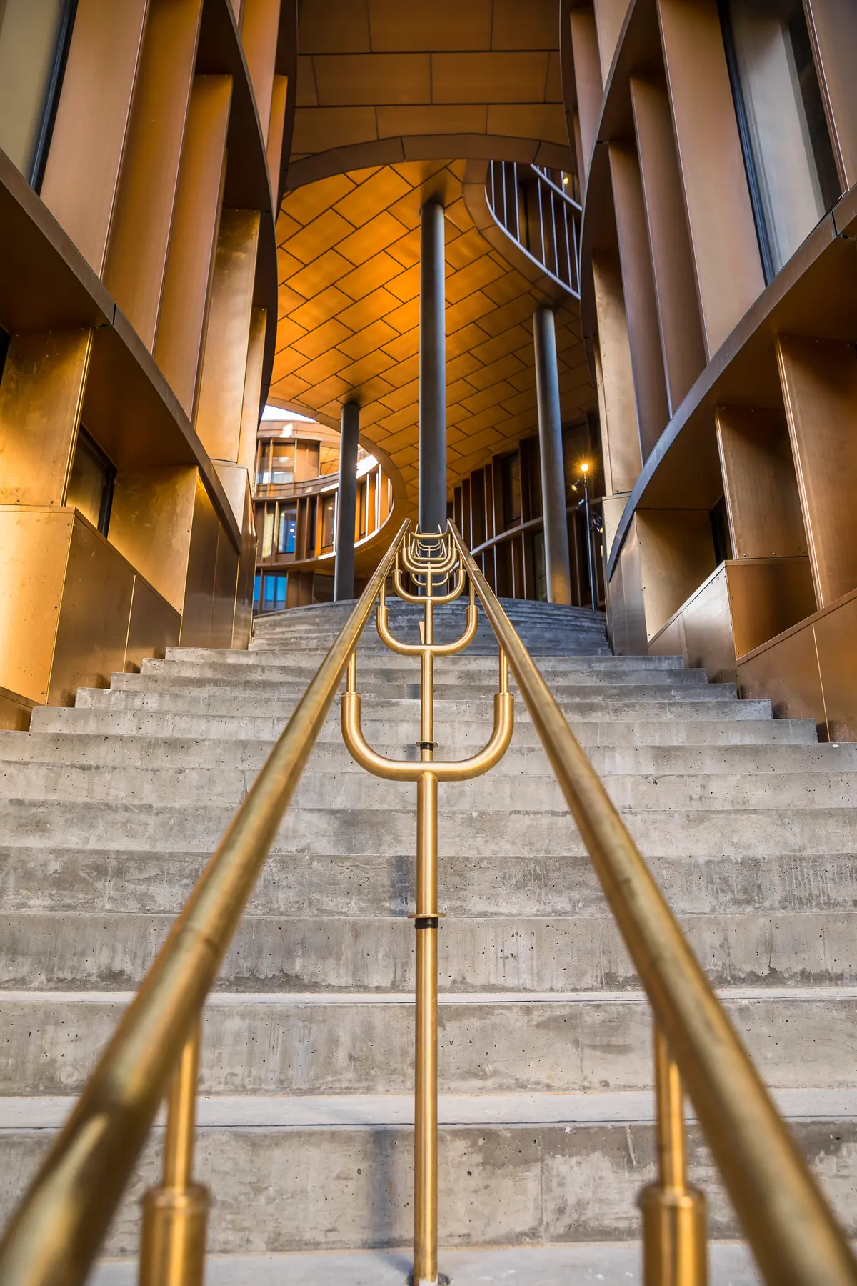 Guldbelagt metalhåndtag på marmorstige i kontorlejemål med 6 meters loftshøjde, lysegul loft og udsigt til Tivoli i baggrunden