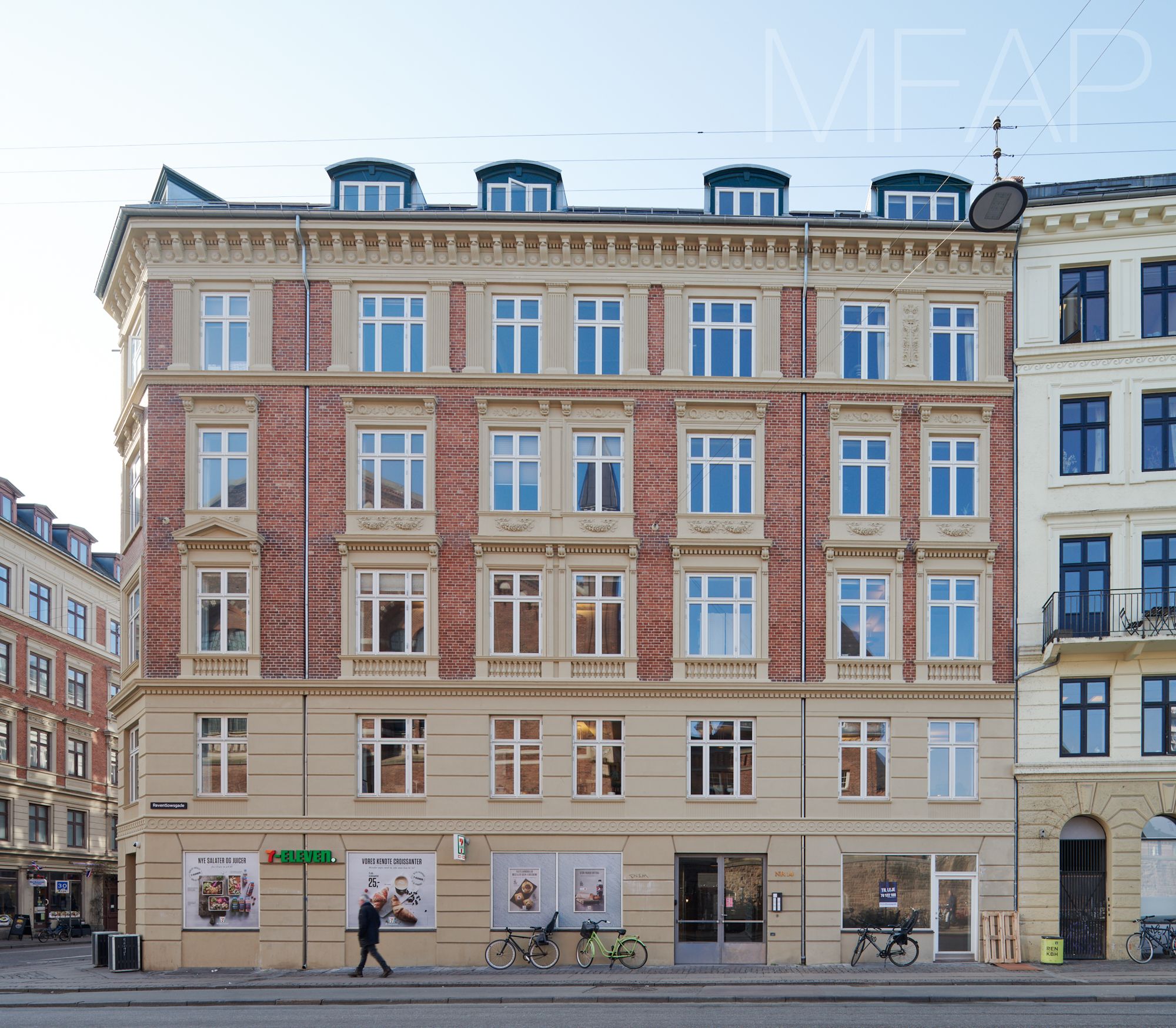 Københavns Hovedbanegård på hjørnet af Istedgade og Reventlowsgade med kontorer, vinduer, bøsser og skovle samt tekst i vindue.