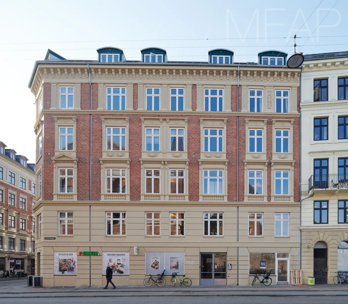 Københavns Hovedbanegård på hjørnet af Istedgade og Reventlowsgade med kontorer, vinduer, bøsser og skovle samt tekst i vindue.