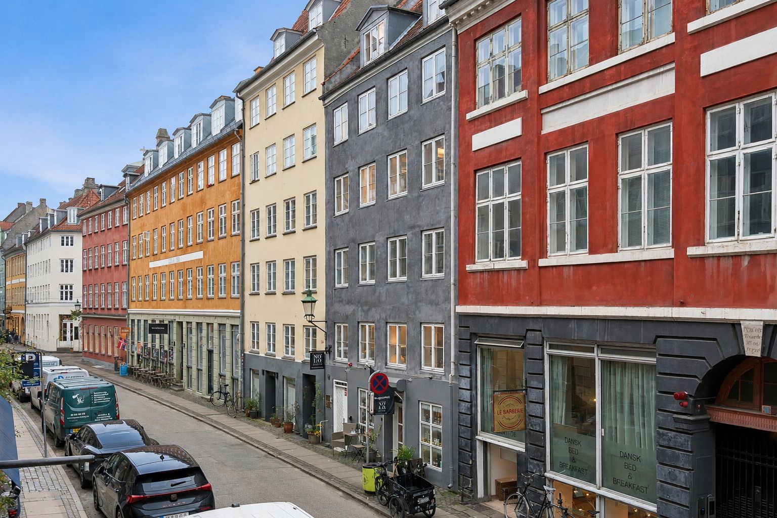 Køretur langs Sankt Peders Stræde, med rækkehus med forskellige farvede facader og kørende biler og motorcykler langs siderne