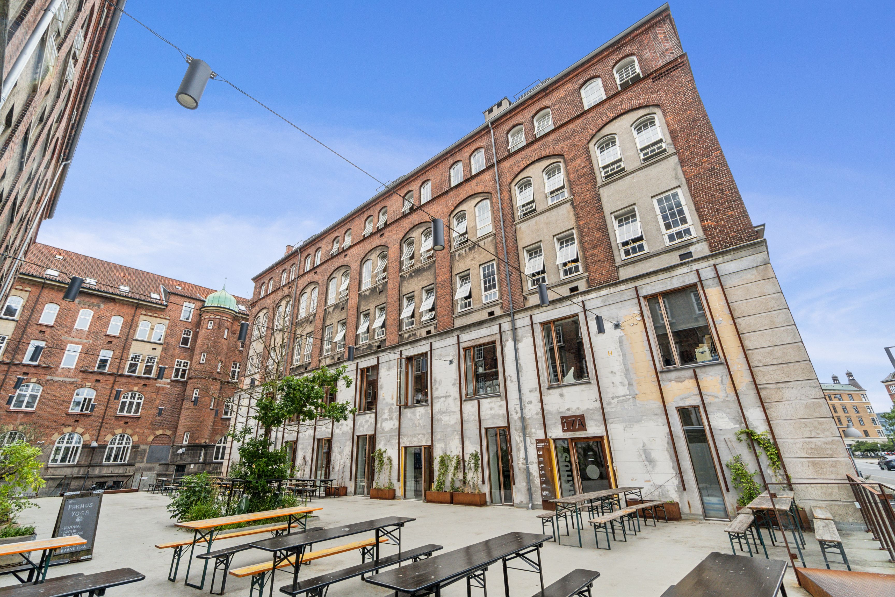 Kontorlejemål med særpræg på Islands Brygge med masser af vinduer og lyse områder. Bygningen med nummer 17A på Njalsgade. Træplanter og bænke med bord og lysekroner.