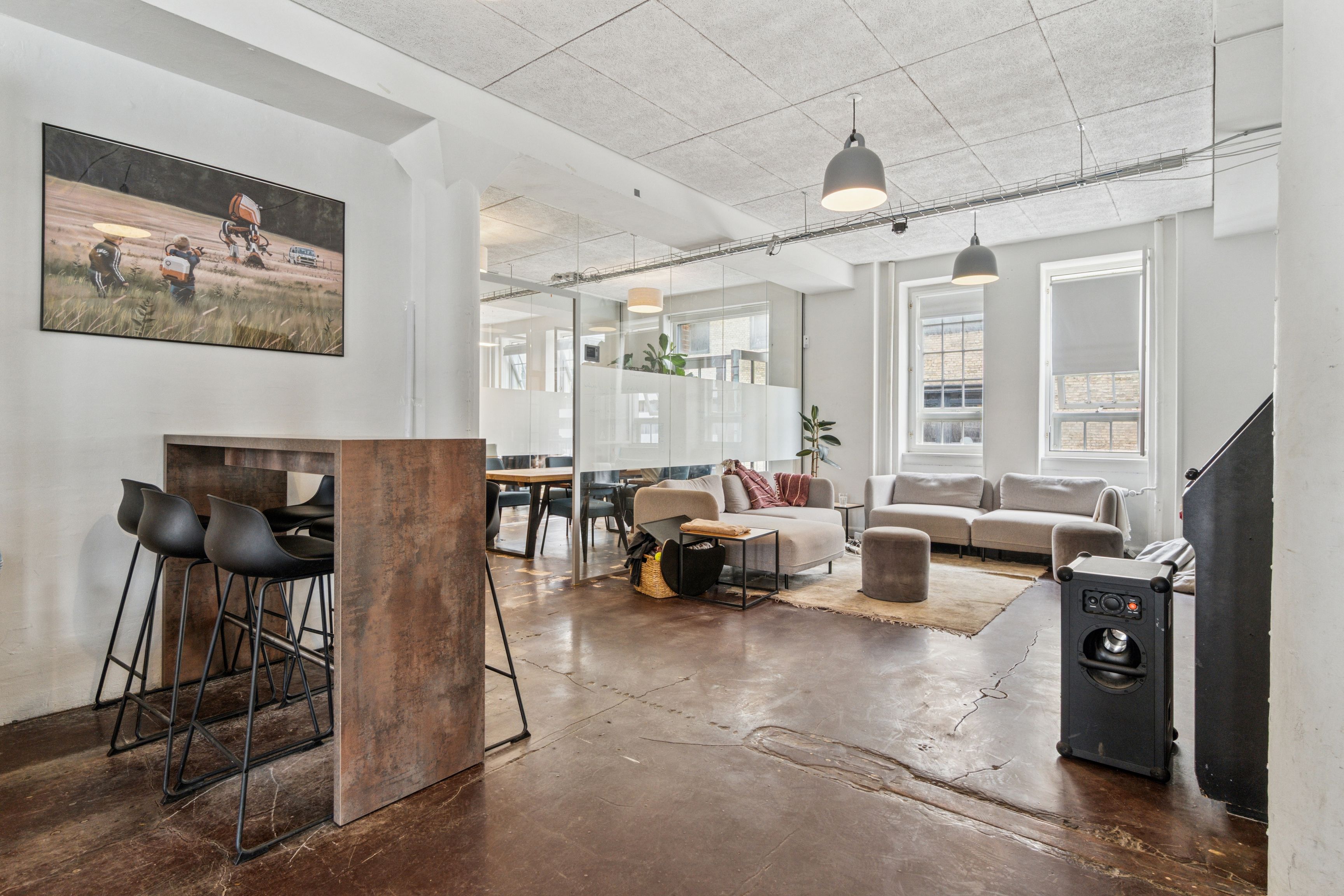 Kontorlejemål på Islands Brygge med lyse områder, lyse lofter, sofaer, borde, stole, lamper og tavle med maleri. Alt integreret i en velrenoveret og moderne indretning