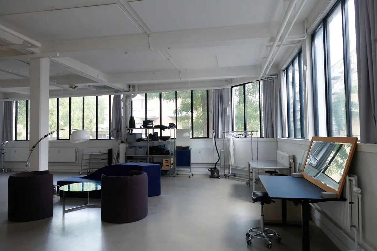 Kontor med lyse gulve, lyse lofter, lyse vinduer og moderne møbler samt højt til loftet