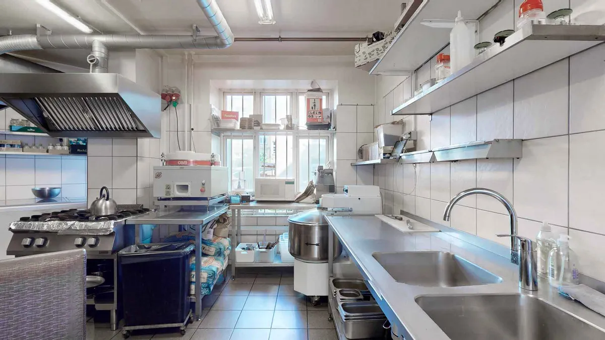 Nyd en enestående erhvervsandel på Jagtvej med et moderne køkken med gaskomfur, kedel, mikrobølgeovn og tørretumbler i fuldt udstyr. Køkken med lyse hvide fliser og lysekroner