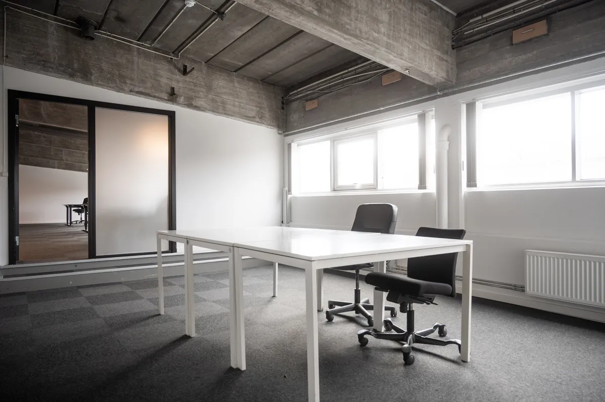 Råt og karakterfuldt kontor i de ikoniske spritfabrikker på Amager. Kontor med hvide vægge, møbler, vindue og trægulv. To kontorlejemål til rådighed.