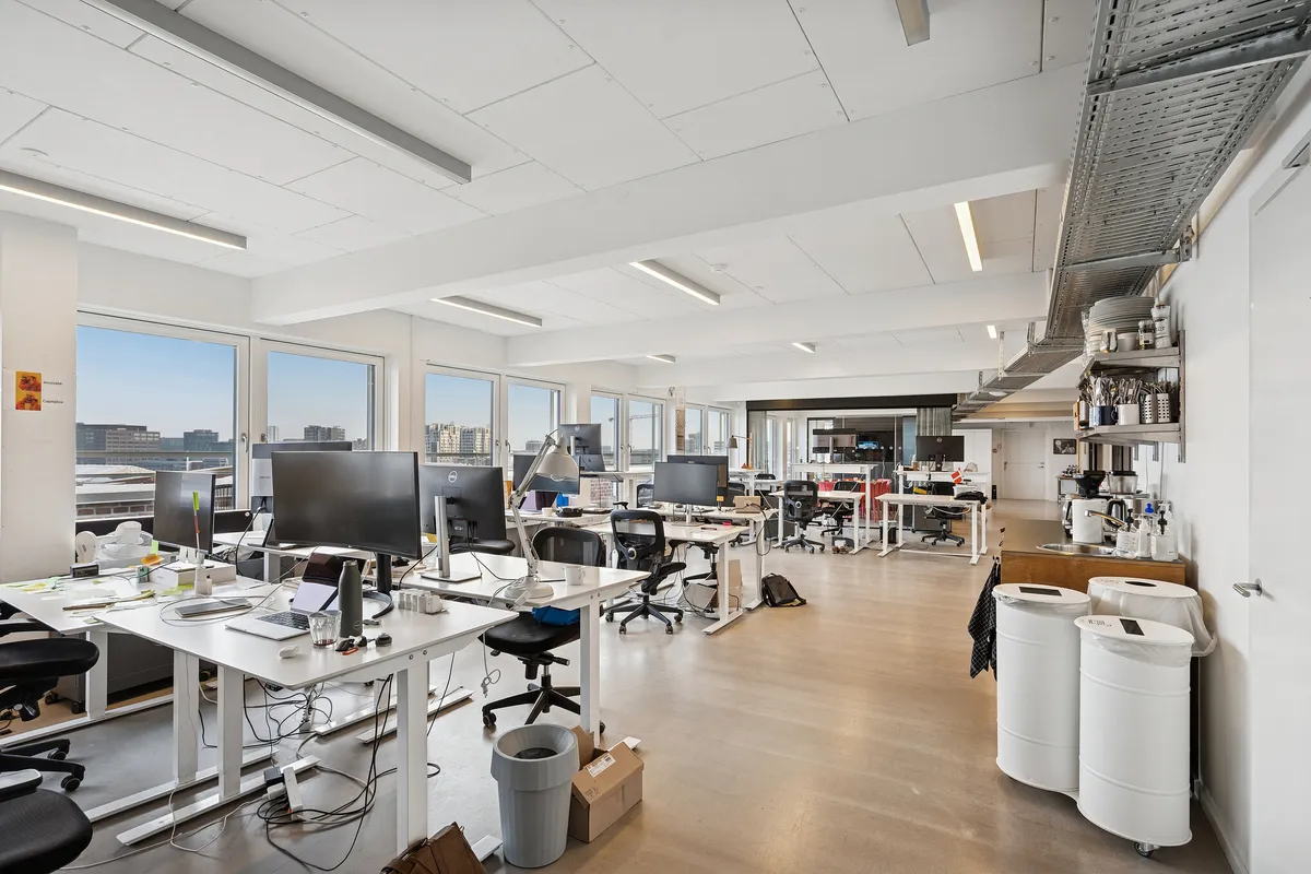 Kontor med høje vinduer og panoramaudsigt over byen og terrasse med udsigt over Kødbyen og bygninger