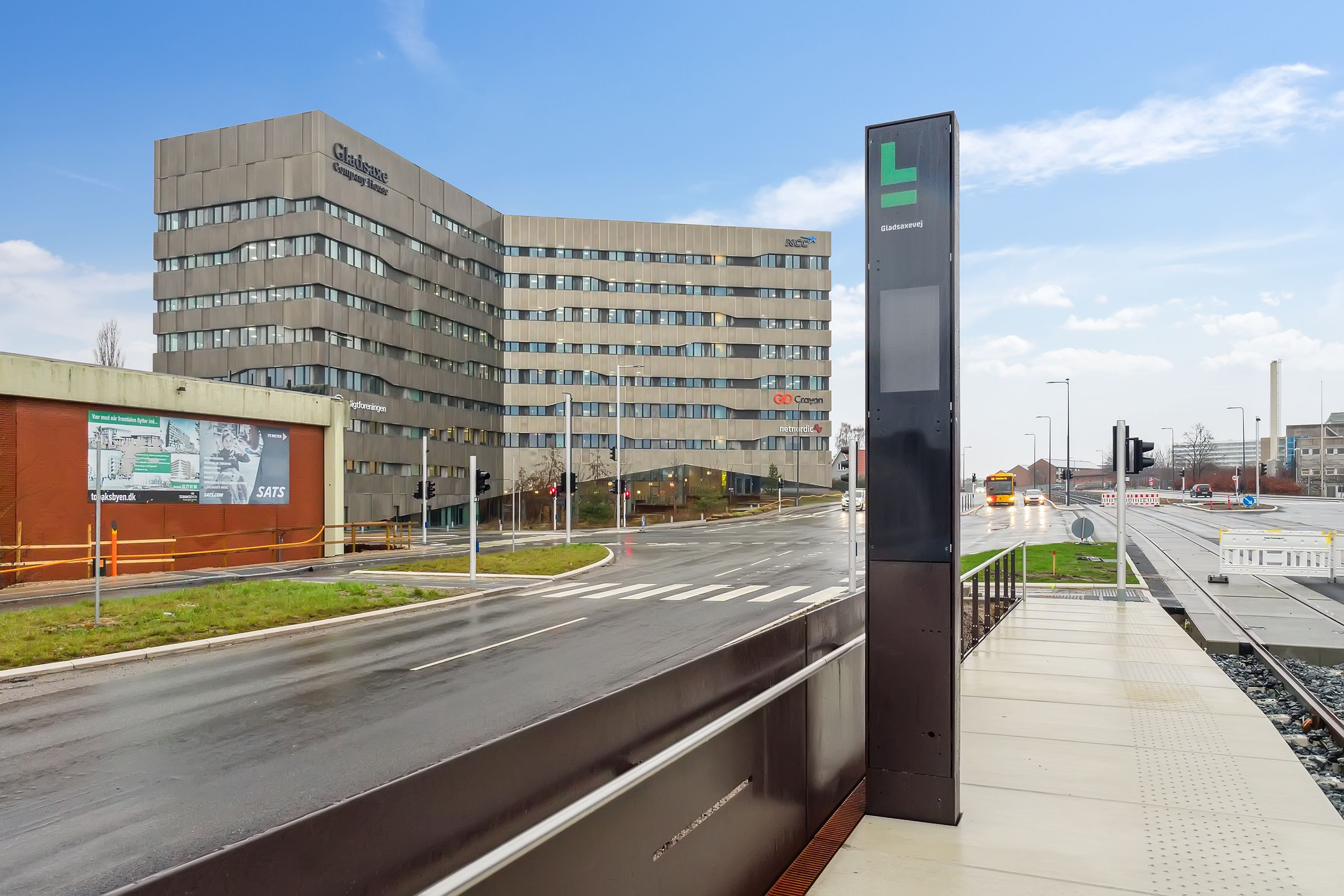 Moderne kontorbygning Gladsaxe Company House med serviceret reception og udsigt over en tom vej med grønne områder og togspor