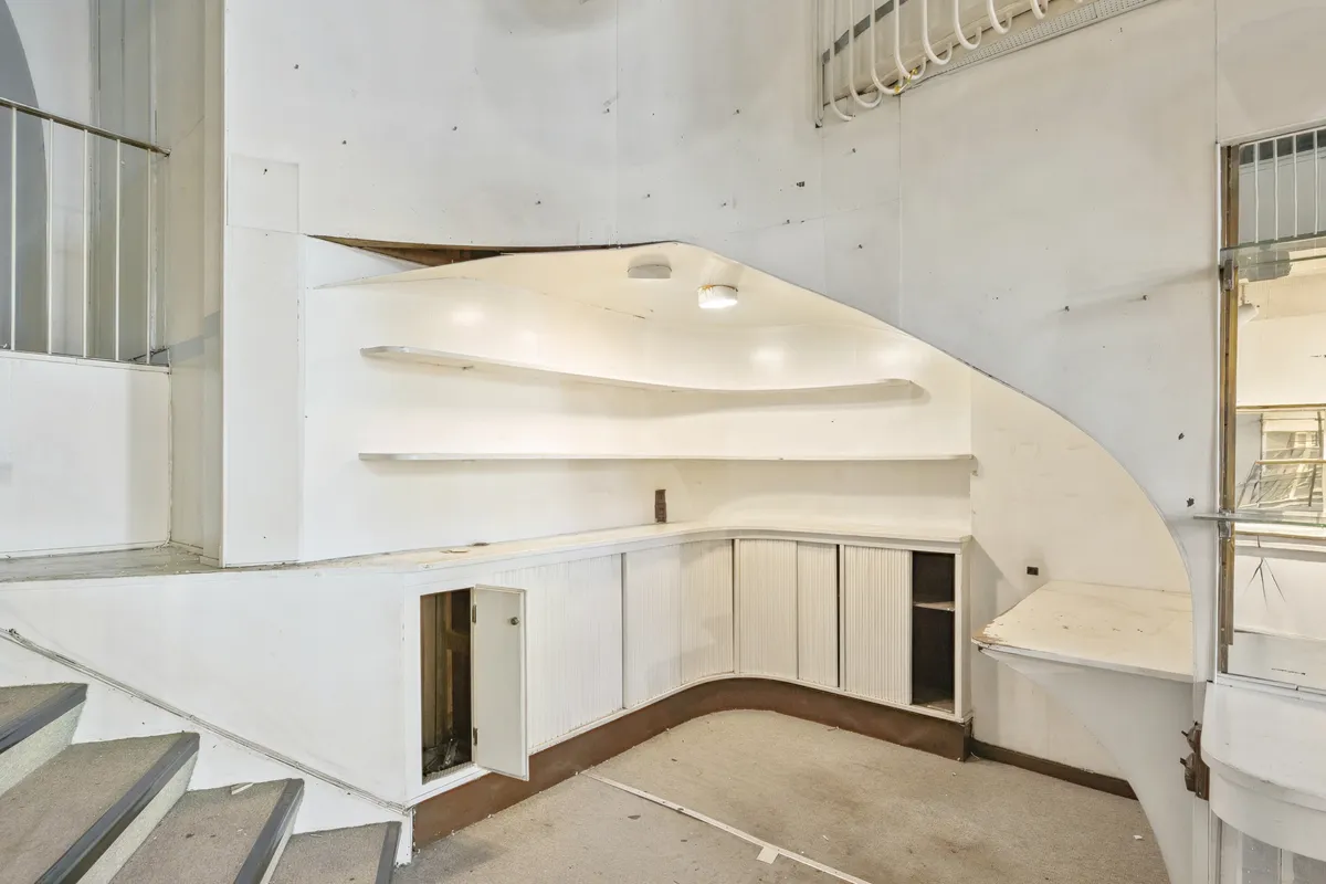 Lejlighed med åbne gulvplaner og lys indretning. Stairs og lyse buede vægge. Skabe og hylder til opbevaring. Moderne design med hvidt og brunt farveskema