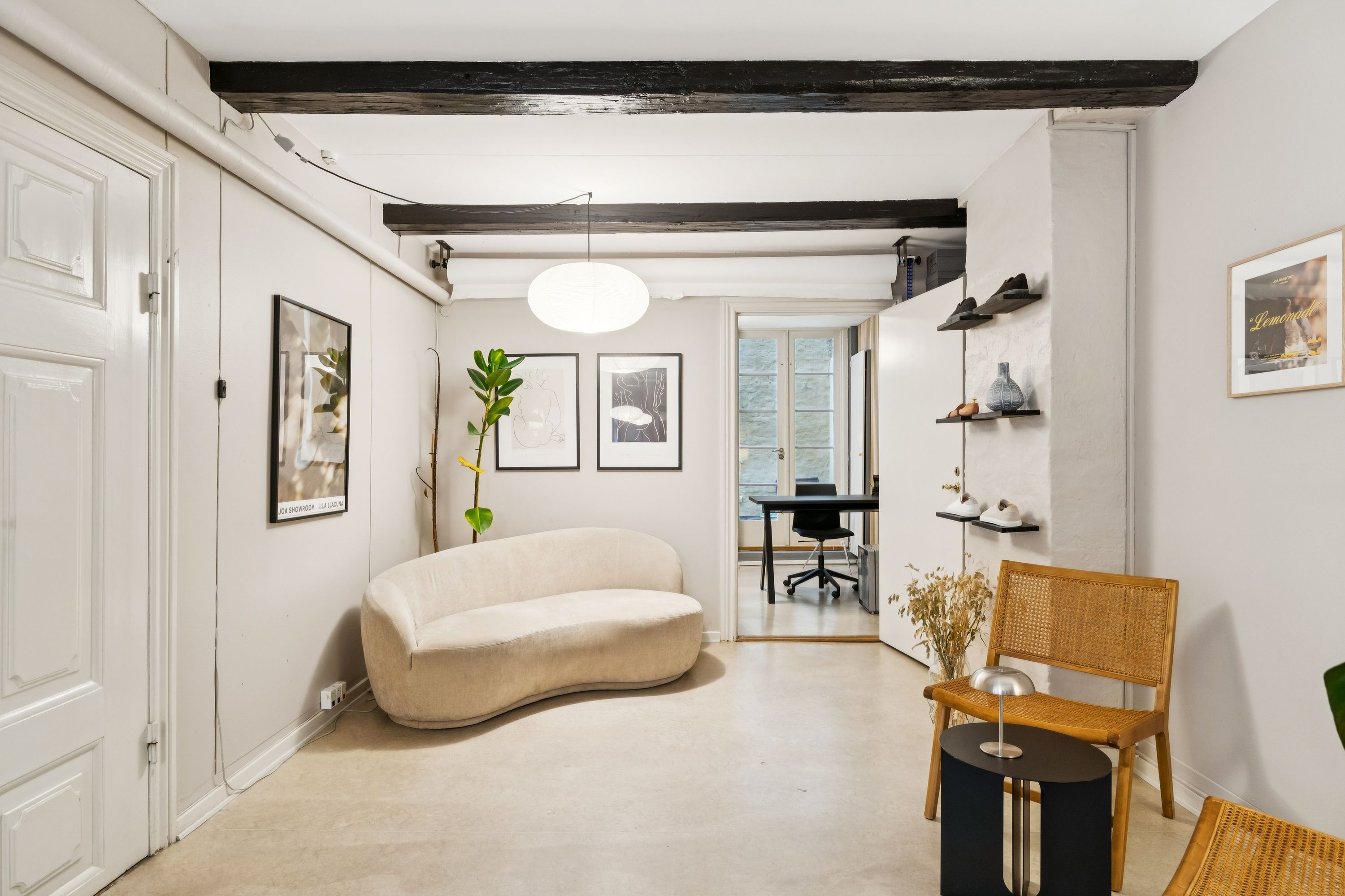 Kontor til leje med stilfuld interiør og møbler, sofa, bord, lampe og kunstværker i en hyggelig og rolig atmosfære