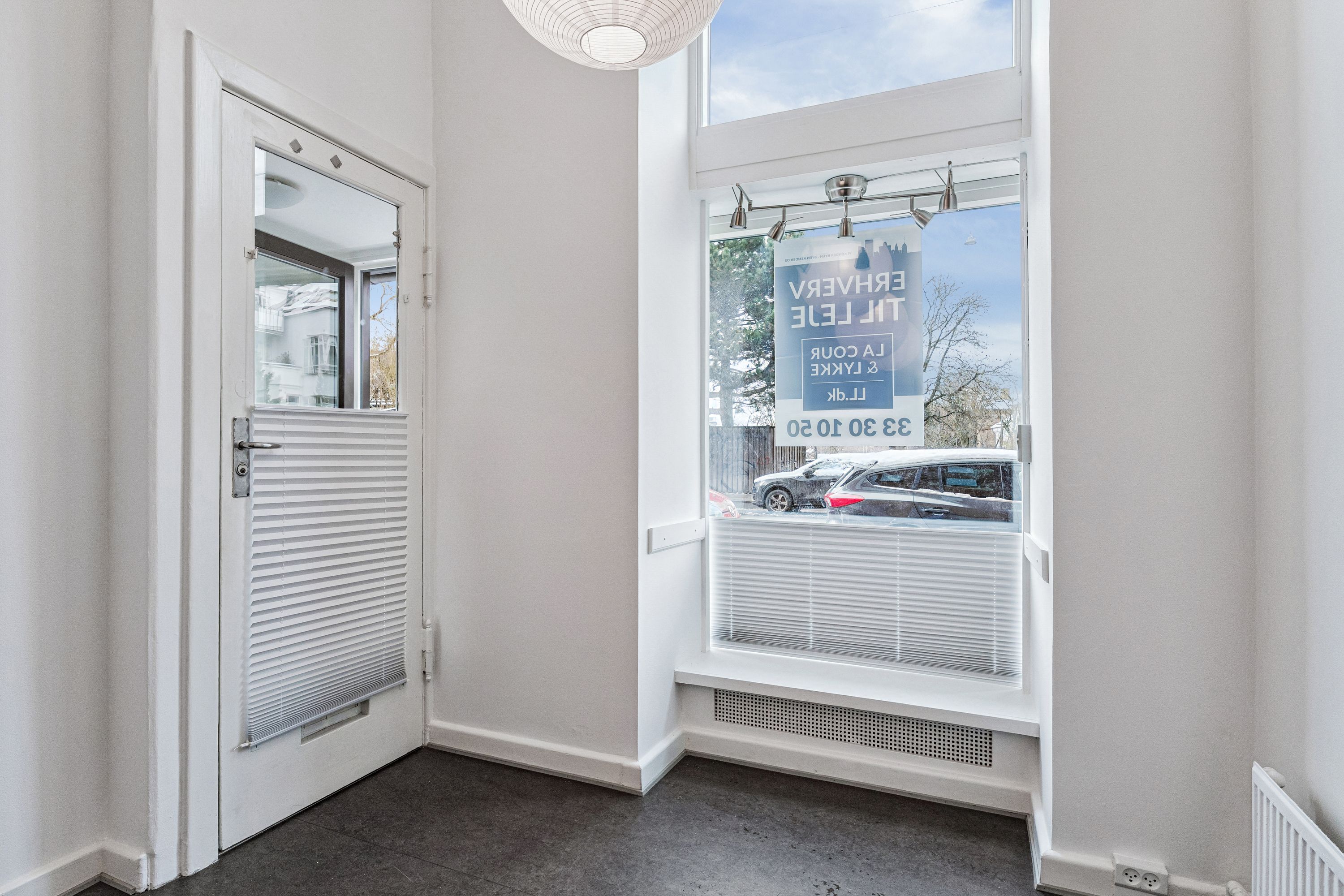 Lejlighed til leje på Søndre Fasanvej 45, st. 3, 2000 Frederiksberg. Indeholder stueplan med højloft og baglokale. Vindue med solskærm og udsigt til gaden med biler.