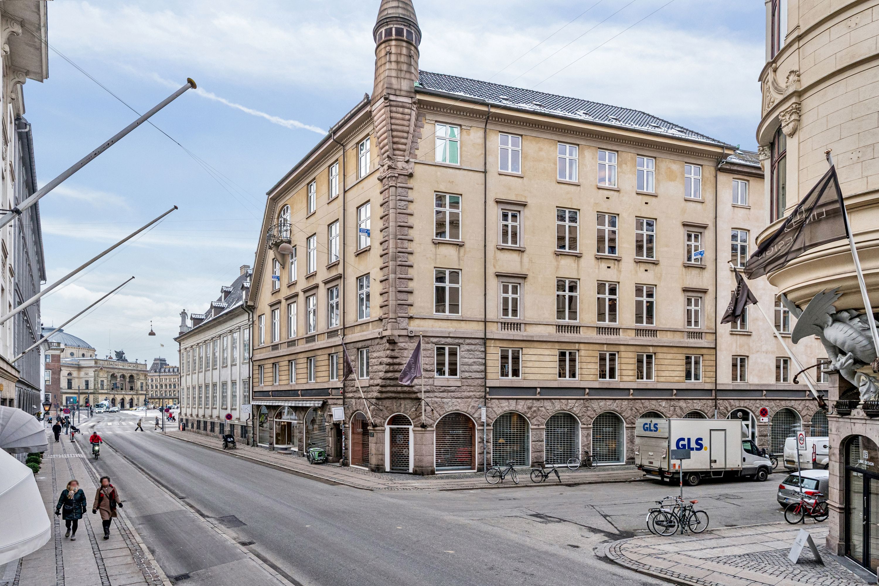 Kontor til leje på Bredgade 3, 2., 1260 København K. Stort hus med mange vinduer og skulpturer. Biler og cykler står parkeret. Mennesker går på fortovet.