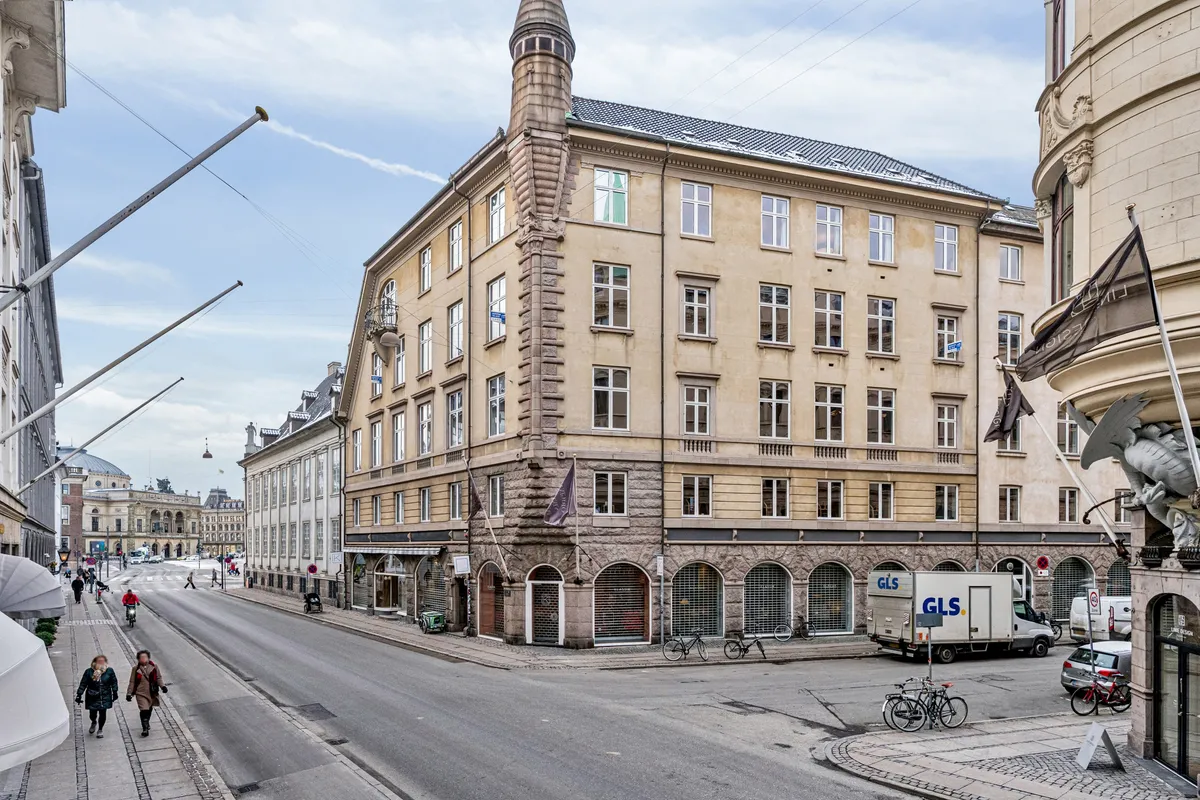 Kontor til leje på Bredgade 3, 2., 1260 København K. Stort hus med mange vinduer og skulpturer. Biler og cykler står parkeret. Mennesker går på fortovet.