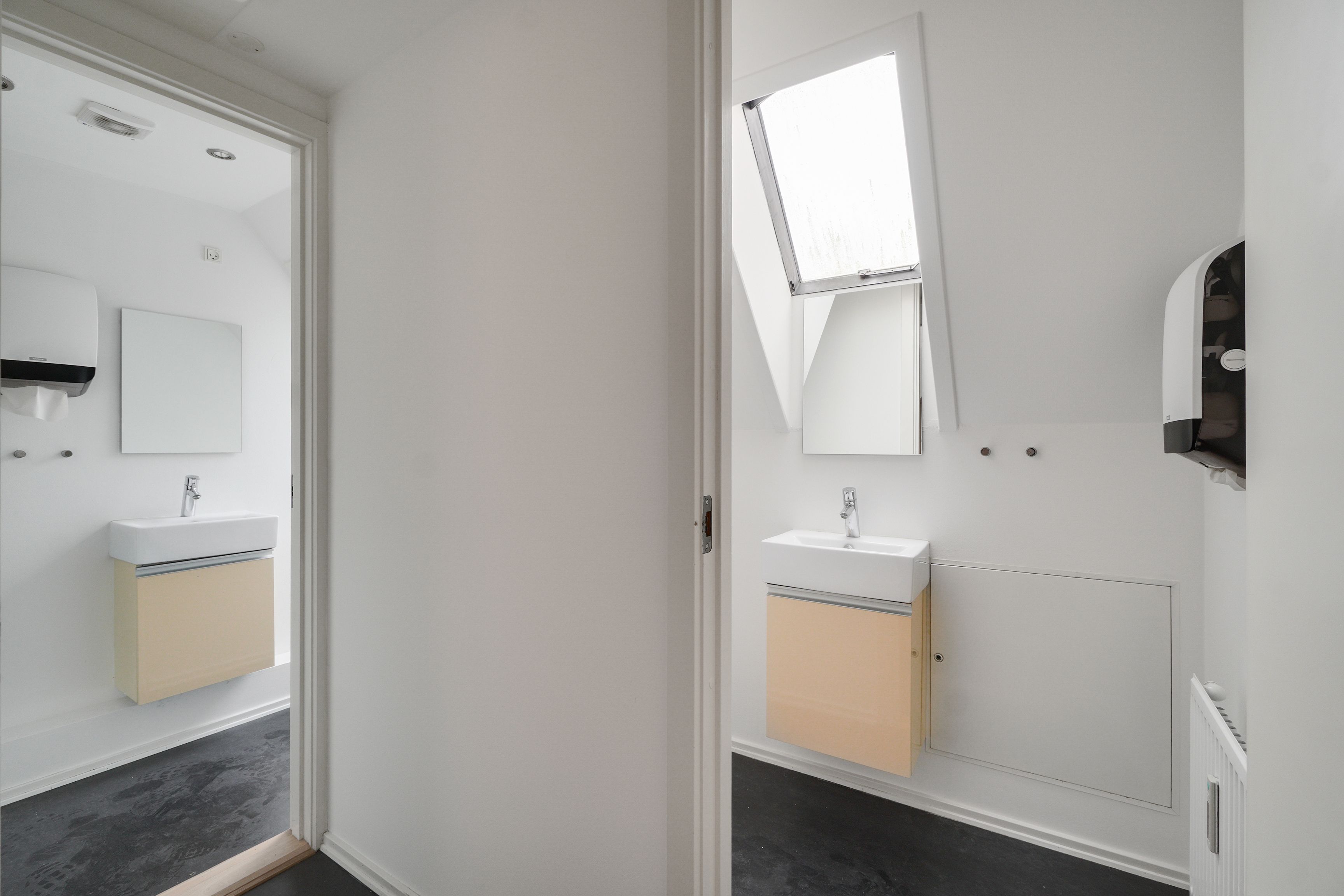 Kontor til leje på Købmagergade 3A, 4. i København. Hvidt, minimalistisk badeværelse med lysegrå gulvbelægning og to vasker med spejle og håndklædeholdere.