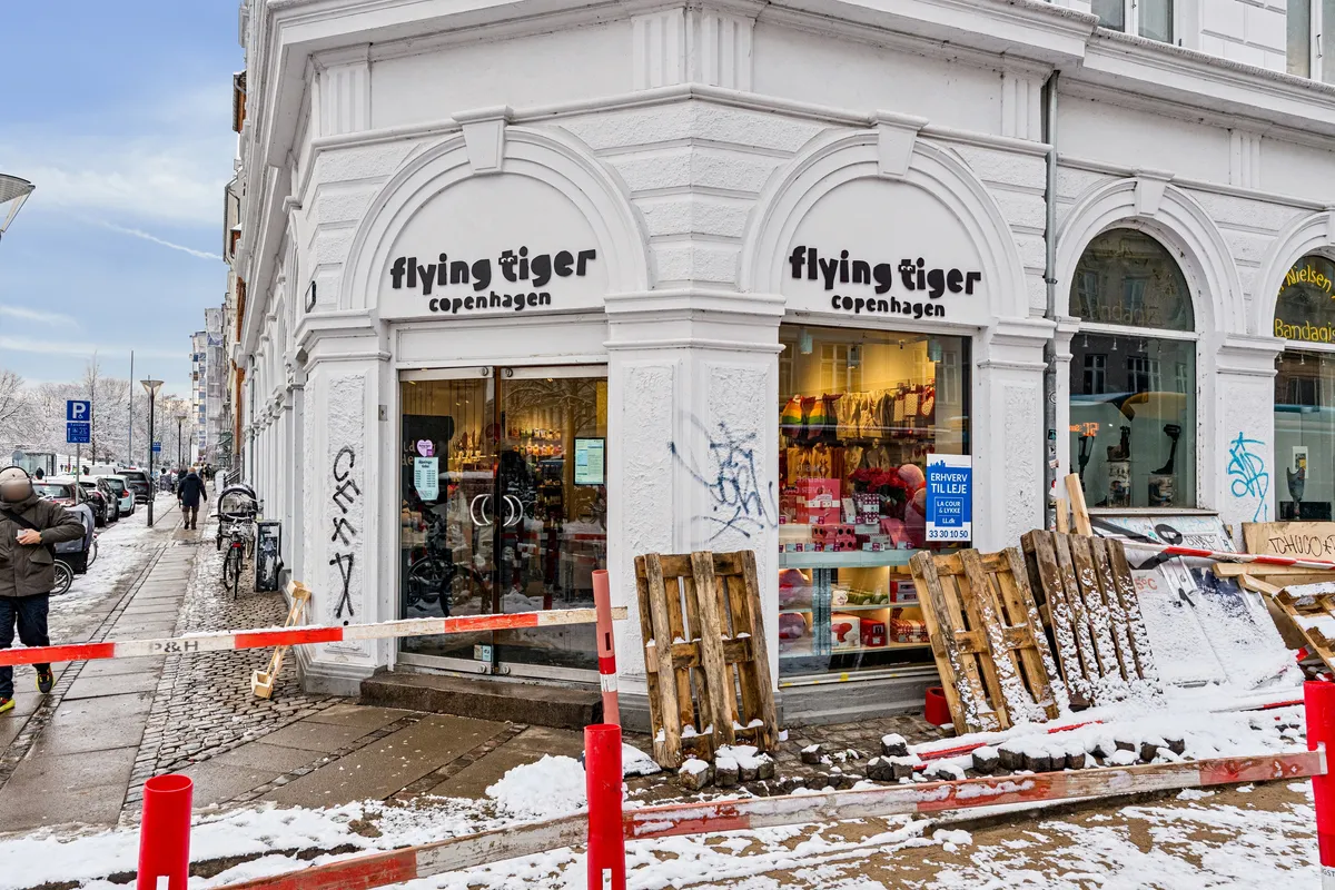 Forretningslejemål til leje på Frederiksborggade 23, 1360 København K. Butik med vinduer og graffiti på facaden. Gangstier og snedækket.