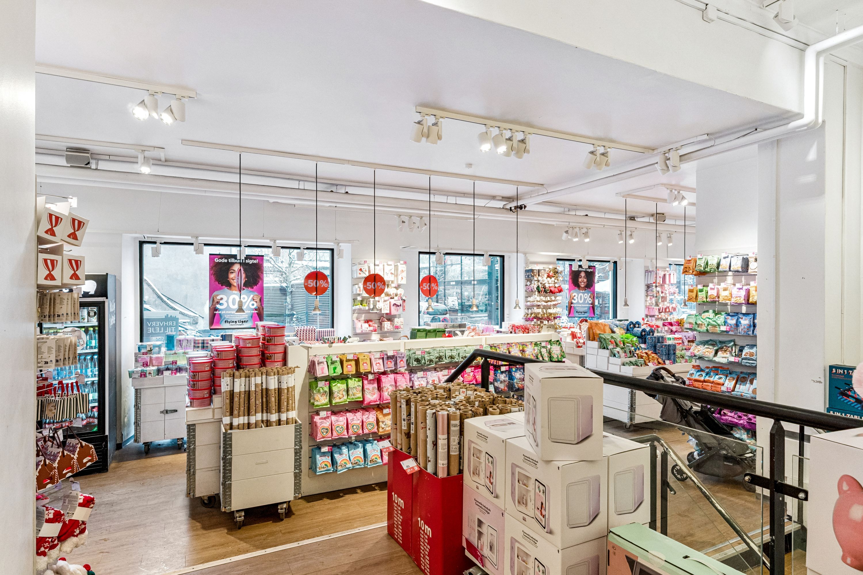 Butik med forskellige produkter og rabatter og en babyvogn på en glastrappe