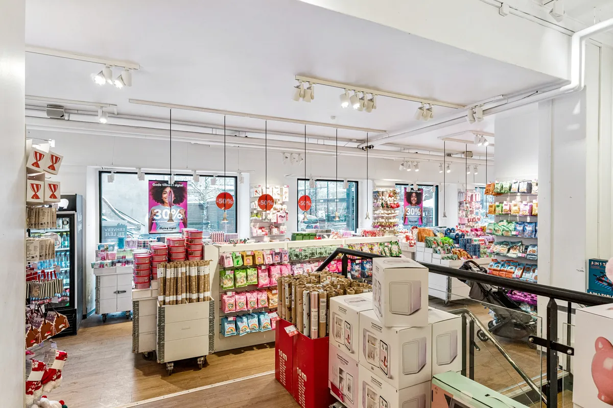 Butik med forskellige produkter og rabatter og en babyvogn på en glastrappe